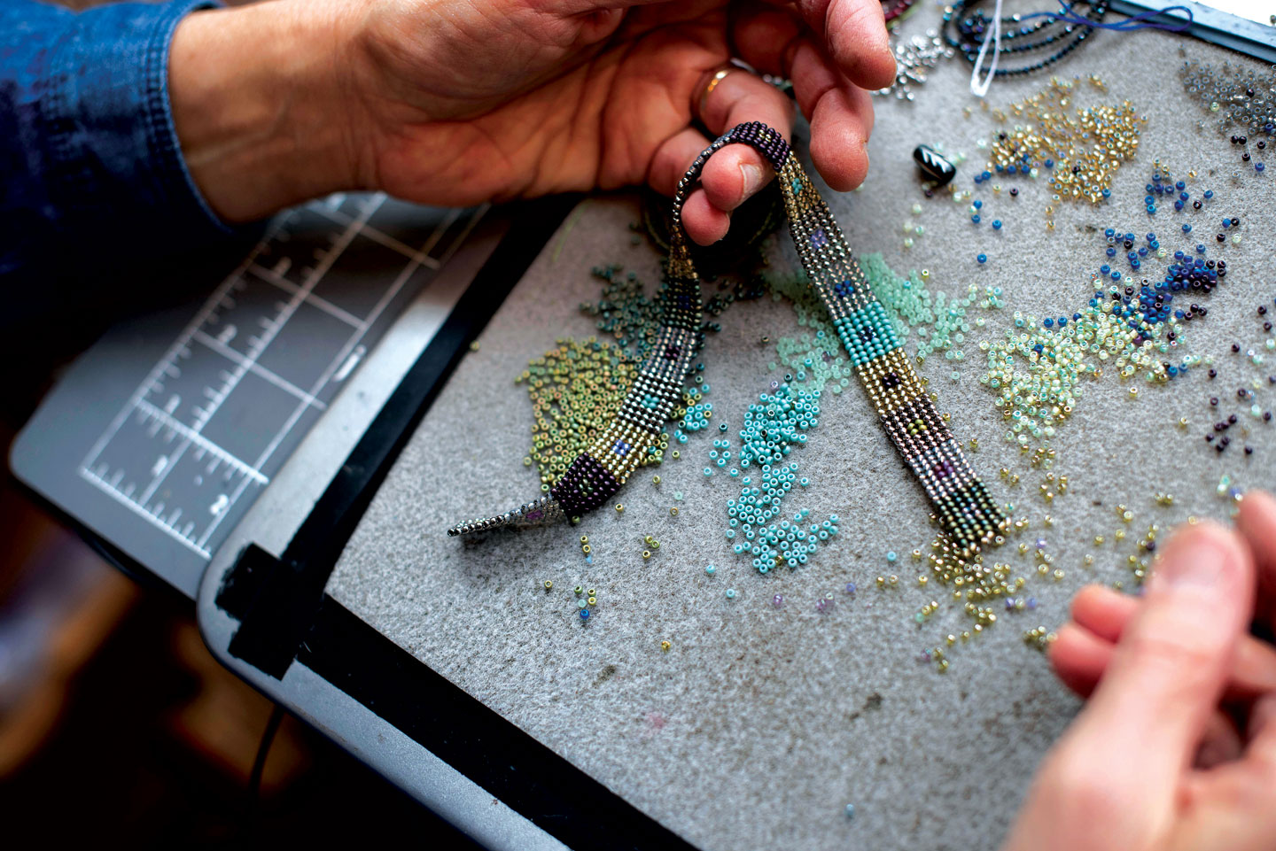 POWELL stringing beaded ribbon in her studio.