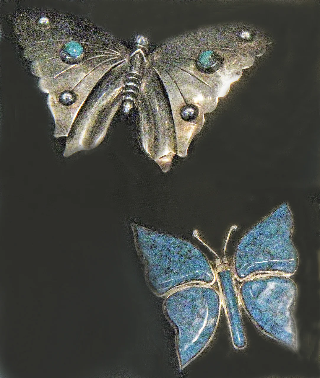 Additional butterfly pins, of later date, from Jonathan Hill booth. Silver one is set with turquoise and silver bosses, while other has bezel-set wings of turquoise.