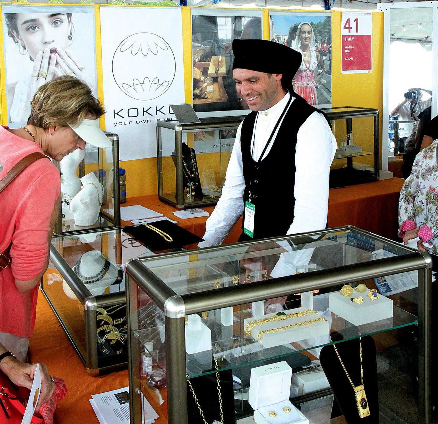 ANDREA USAI, of Kokku, from Sardinia, an island off Italy, with a client in his booth.