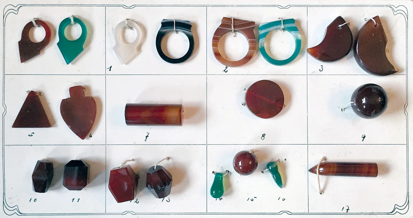 GEBRÜDER WILD COMPANY BEAD SAMPLE CARD, showing a wide range of Idar-Oberstein agate ornaments, including some rarely seen in the African trade. The top row displays talhakimt , turmrings and simulations of feline claws.