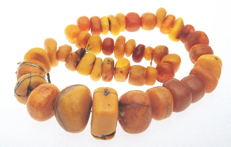 Superb strand of copal and amber from Morocco, maximum size of beads 5.8 cm wide; note repair to beads by binding with metal wire or bands, or with corrugated staples. Courtesy of Wind River. RKL