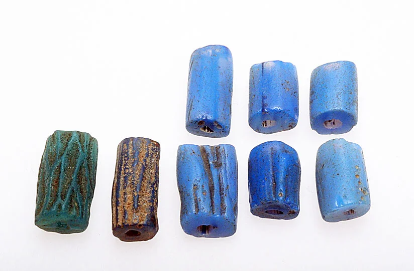 An array of dichroic, corded beads from Nigeria (6 medium blue on the right) and their Czech imitations on the left; the longest are 1.5 cm. The imitations are pressed or molded and are not of dichroic glass. RKL