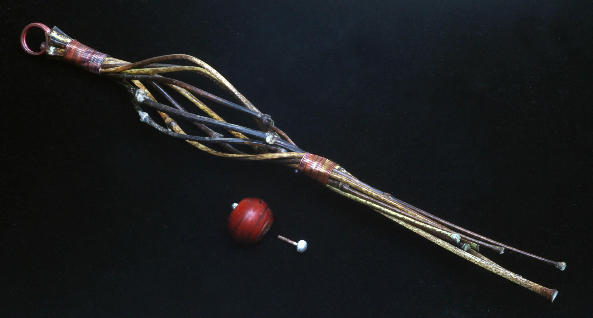 ALMOST FINISHED VERTICAL JIGGED PENDANT; the pendant has a soldered copper loop and is wire-wrapped with annealed, fire-colored 26 gauge copper wire, applied after bound culms have thoroughly dried. Vintage Venetian Corneline del Alleppo glass bead has silver topped caps, shown before final assembly with glue. Notice the tight wire-wrapping, which follow the shape of the underlying bamboo culms.
