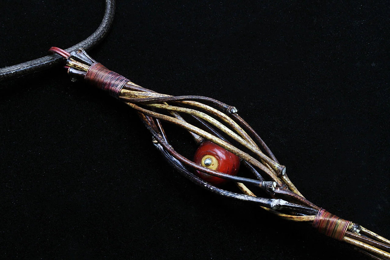 DETAIL OF FINISHED TORQUE WITH VERTICAL JIGGED PENDANT, showing the CdA bead trapped inside jigged space, so that it can freely move. Note silver bead cap and how tight wire-wrapping allows bundled bamboo culms to show through.