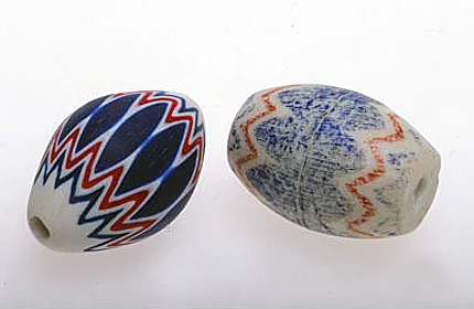 Contemporary polymer chevron replica (left) and Prosser imitation chevron, very worn, from the African trade (2.2 cm long). RKL