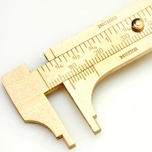 Brass calipers, with upper measurements in inches, lower in millimeters. CW