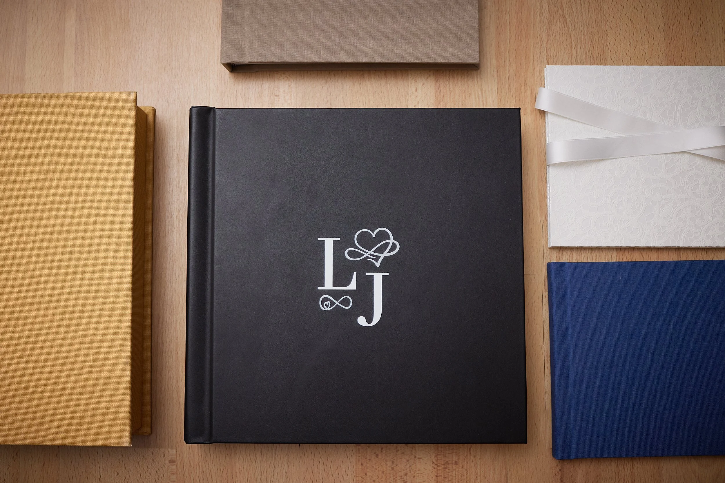 Sort album med initialene L og J og hjerte- og infinity-symboler, omgitt av andre albums i gull, grå, hvit og blått.
