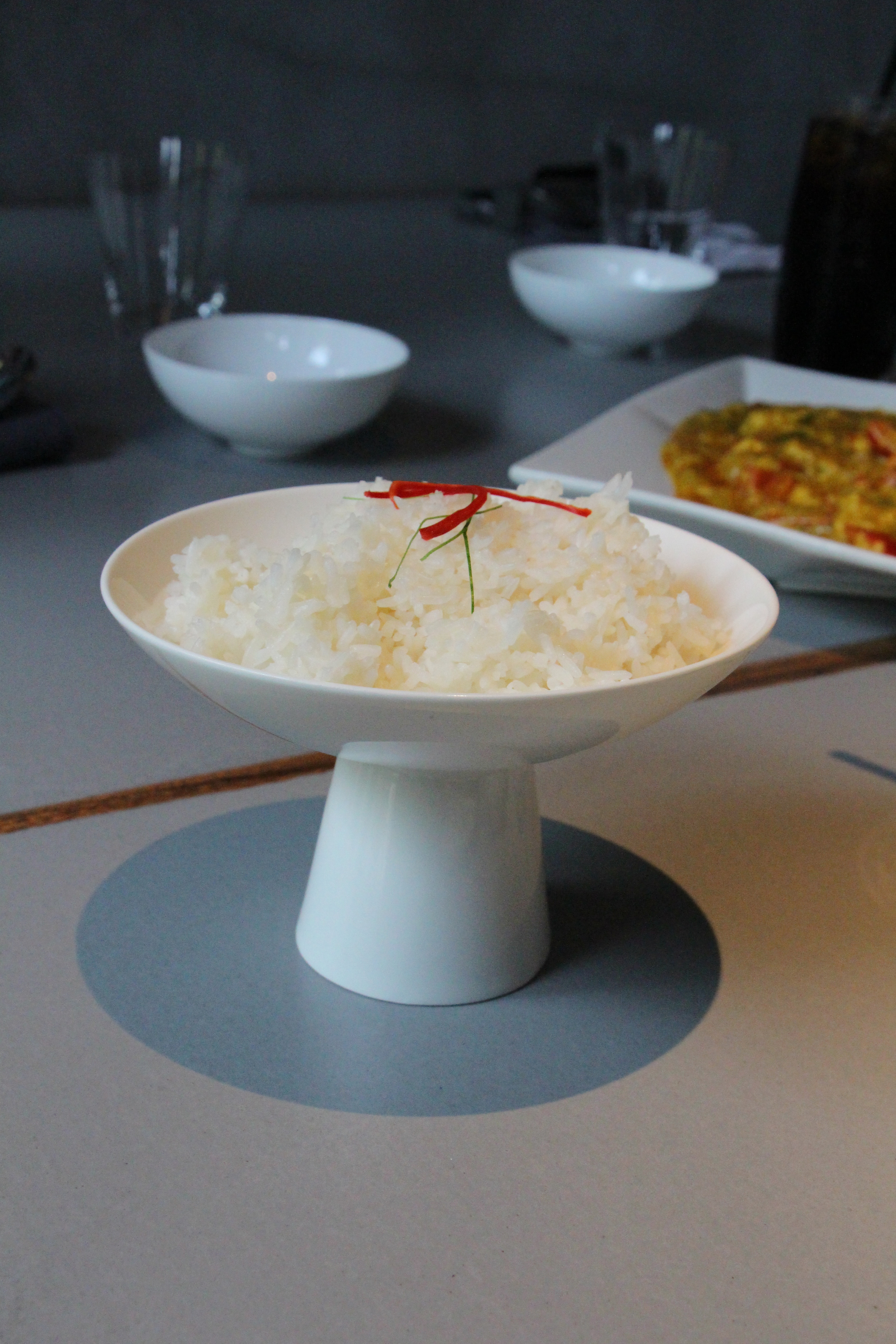 Small portioned rice, but is presented in an eccentric little bowl 