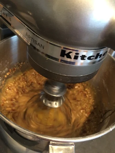 Mixing the pecans with the eggs, corn syrup, vanilla, sugar, and butter.