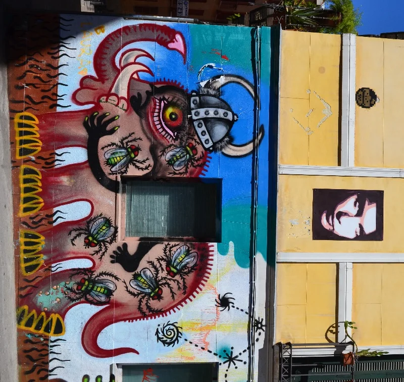 Street art at Plaza Juan Pujol. The two posters on top are painted on cardboard. Late at night, you’ll sometimes glimpse street artists carrying a ladder as a well as paint. Getting their work in hard-to-reach places has become a badge of pride.