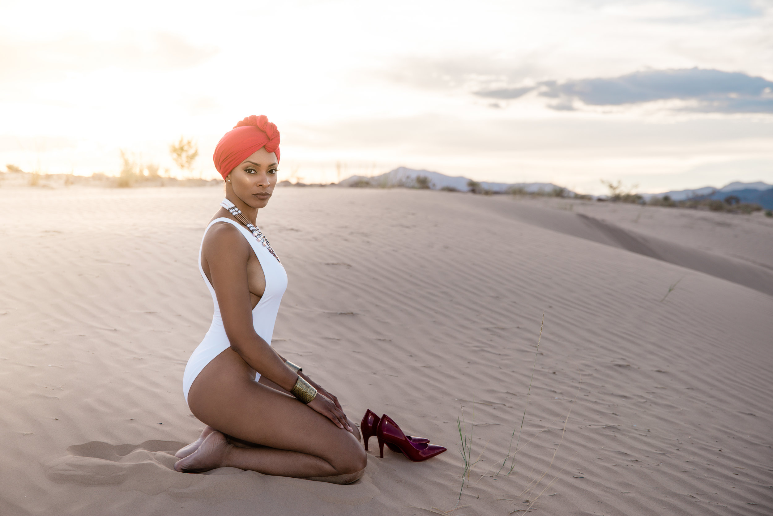 strong gorgeous woman on desert sand dunes with red turbant