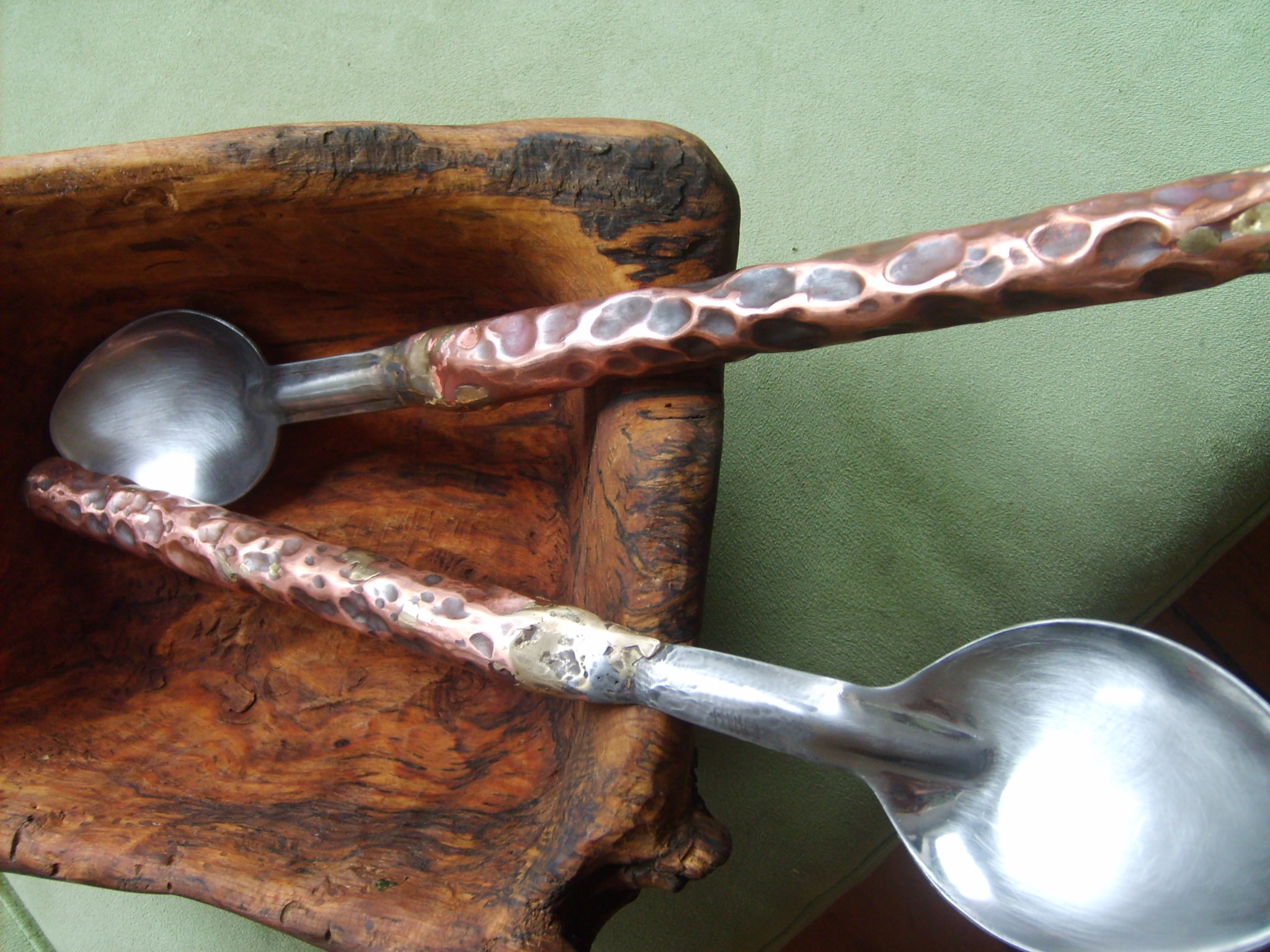 Carved wooden salad bowl and copper hammered serving spoons