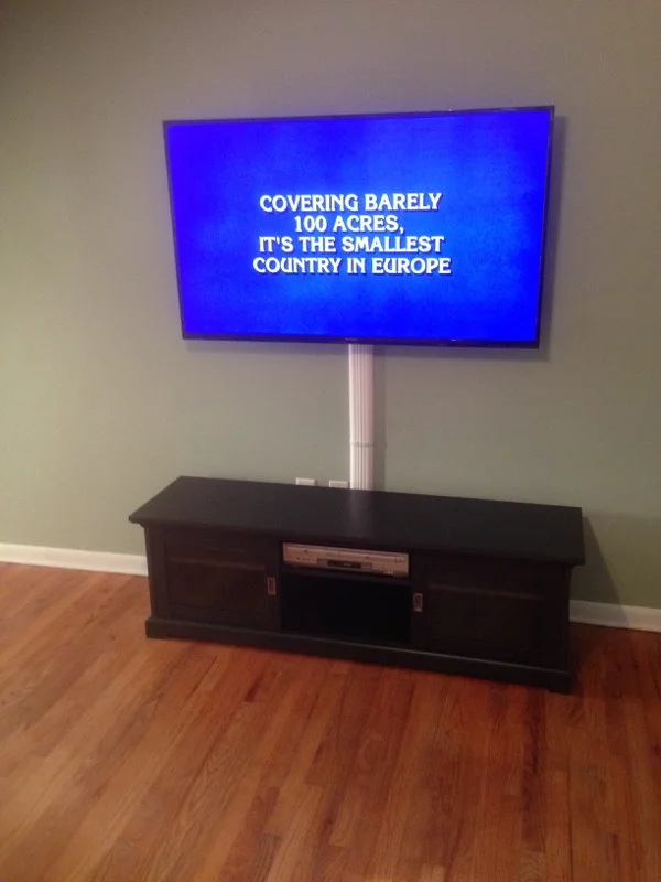 Flatscreen TV mounted, wires secured, Comcast Remote Programmed