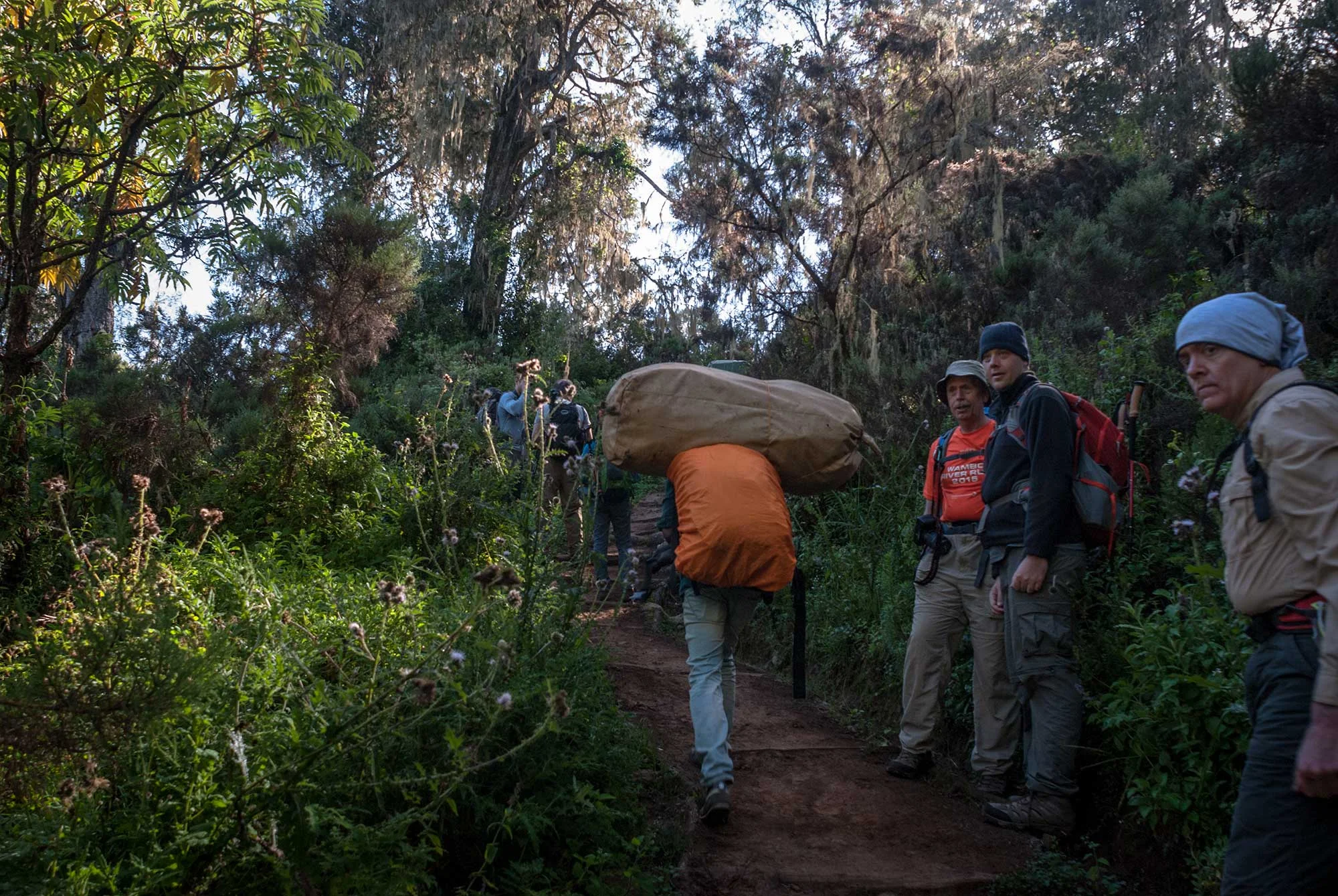 Marc, Ryan, and John step aside to let a porter pass on the narrow trail.