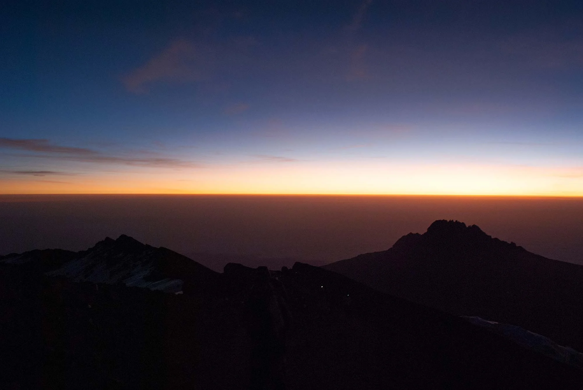 Looking East toward Mawenzi, Kilimanjaro's youngest of its three peaks. The headlamps of two climbers are visible on the mountain.