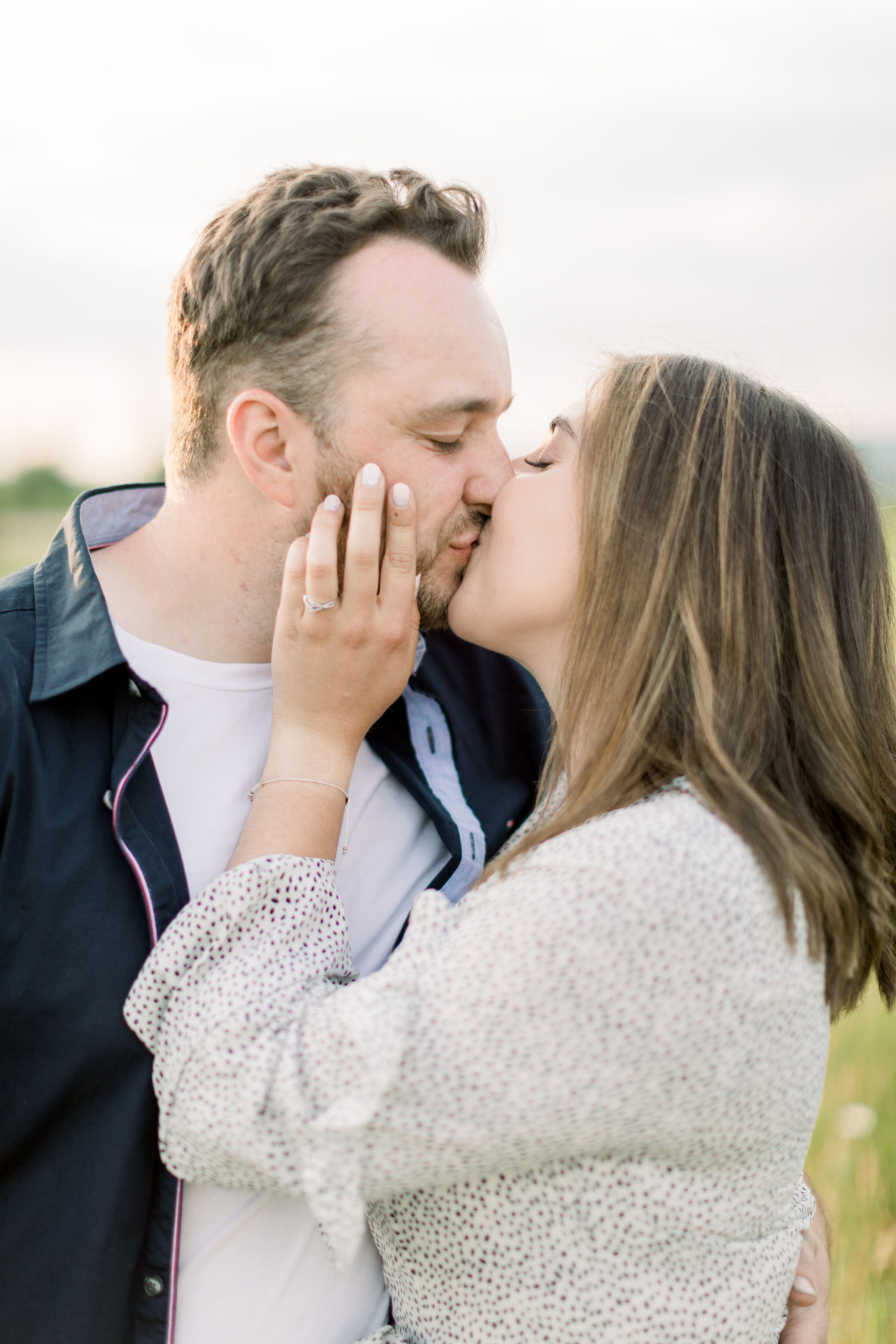  Close up shot of engagement session with bride wearing a white dress with black polka dots in this spring photoshoot by Chelsea Mason in Ottawa, ON. outfit ideas for spring photoshoot white and black outfit dress ideas for engagements white polka do