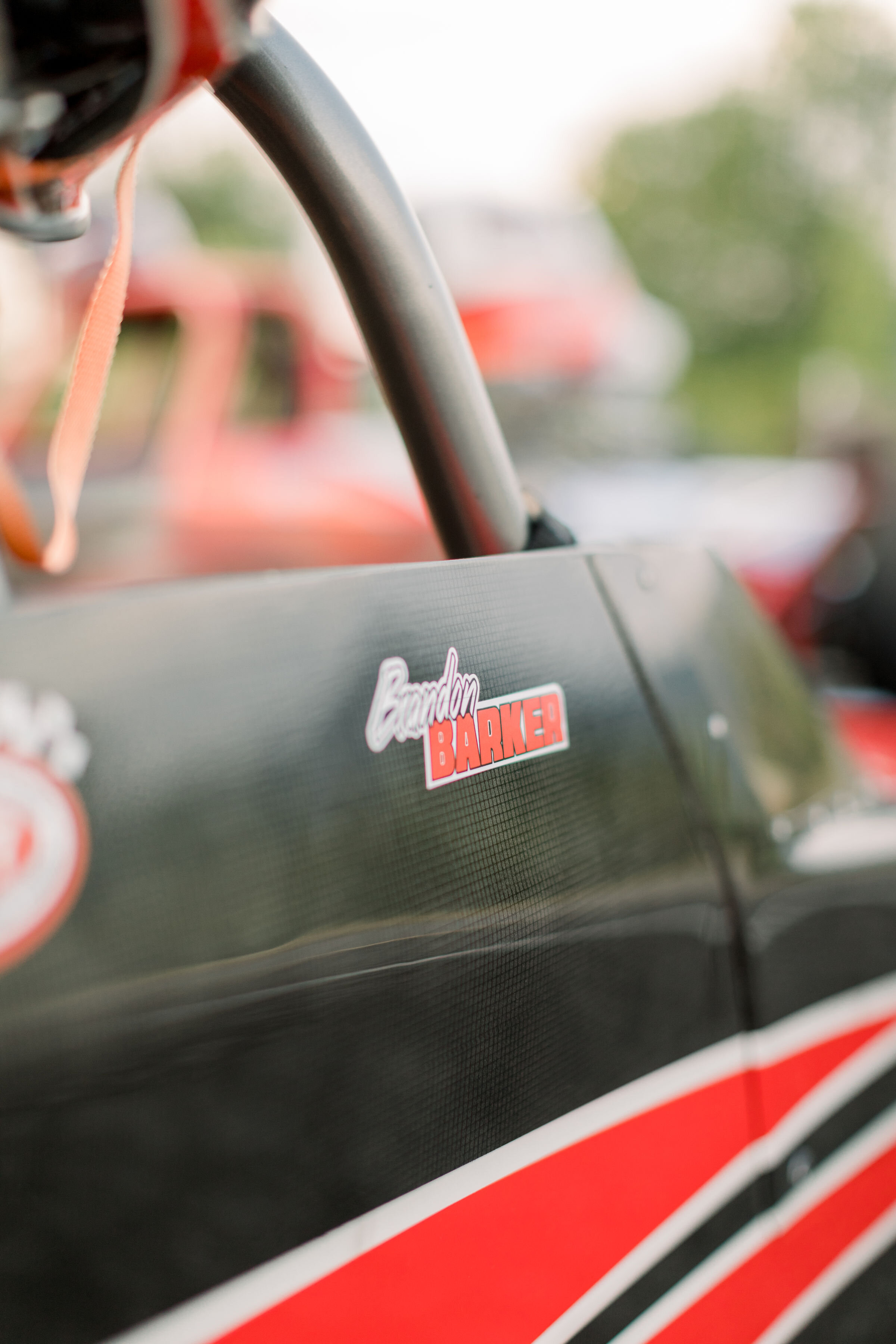  Close up detail shot of Barker race car that is black and red with stripes featured in engagement photoshoot in Ottawa, ON by Chelsea Mason photography. race car black and red wedding photography best photography in ottawa carleton palce kingston pe