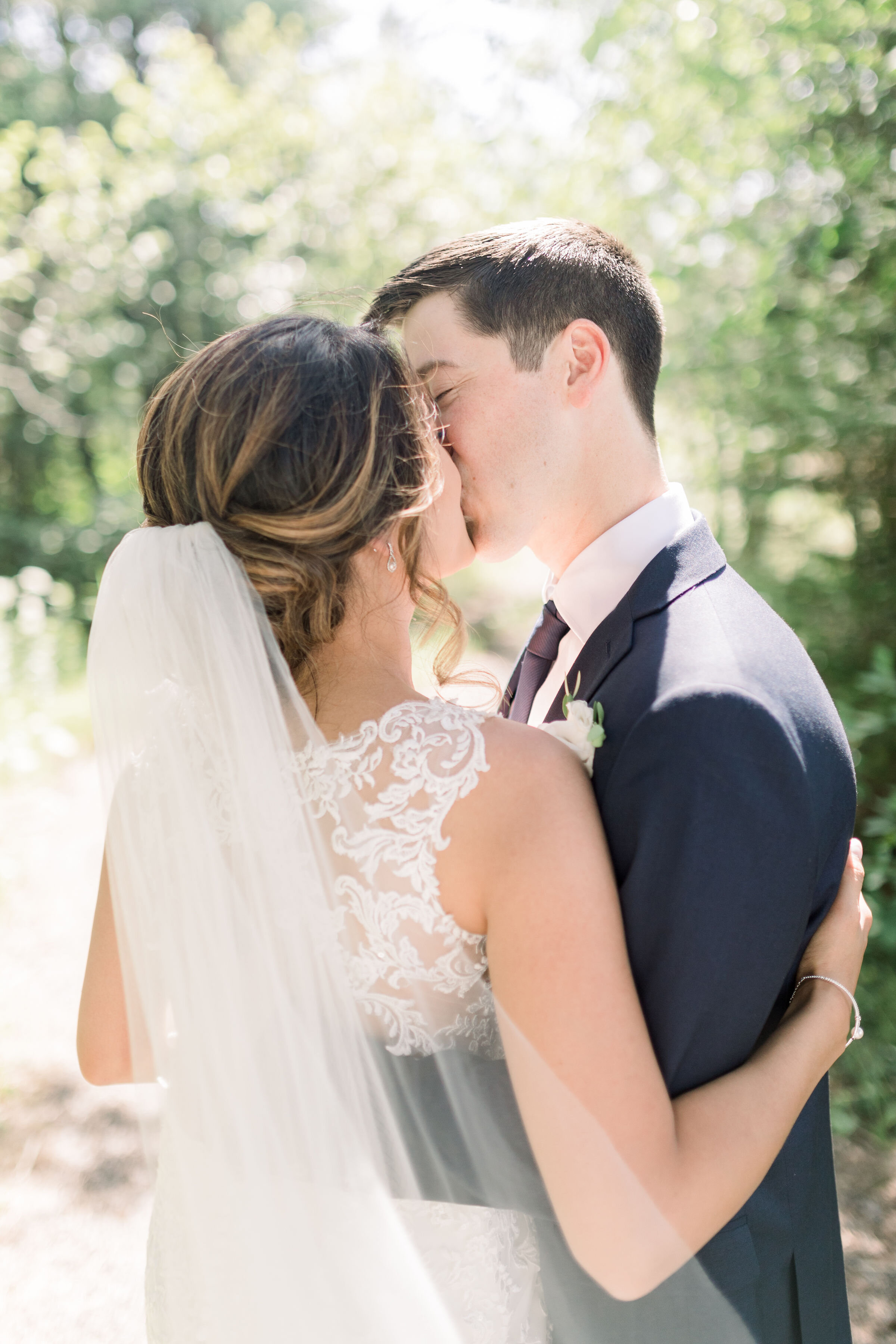  Bride with lacy dress and long veil in her low and loose updo for wedding and groom in blue suit in Ottawa, ON by Chelsea Mason Photography. wedding dress inspo lace wedding dress back of wedding dress inspo veil for wedding veil wedding hairdos upd