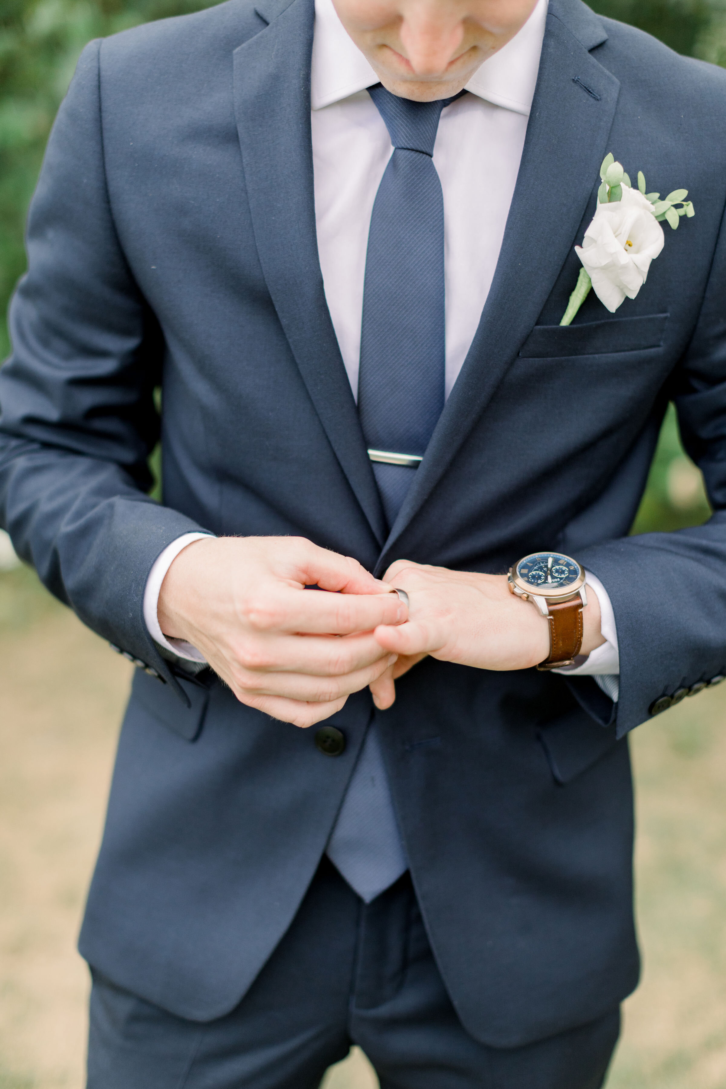  Handsome groom with navy blue suit and light blue tie and wedding ring and watch by Chelsea Mason Photography in Ottawa, ON. how to style your groom wedding styles for grooms navy suit for groom blue wedding colors groom outfits for wedding best col