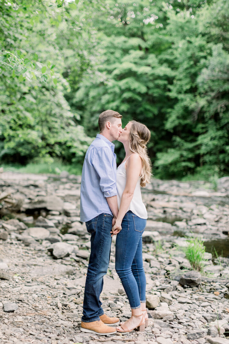  Adorable kissing photo of couple in the woods during engagement photo session in Ottawa, ON by Chelsea Mason Photography. outdoor photoshoot locations in ottawa kissing poses for couples how to photograph kissing best poses for engagements pretty ou