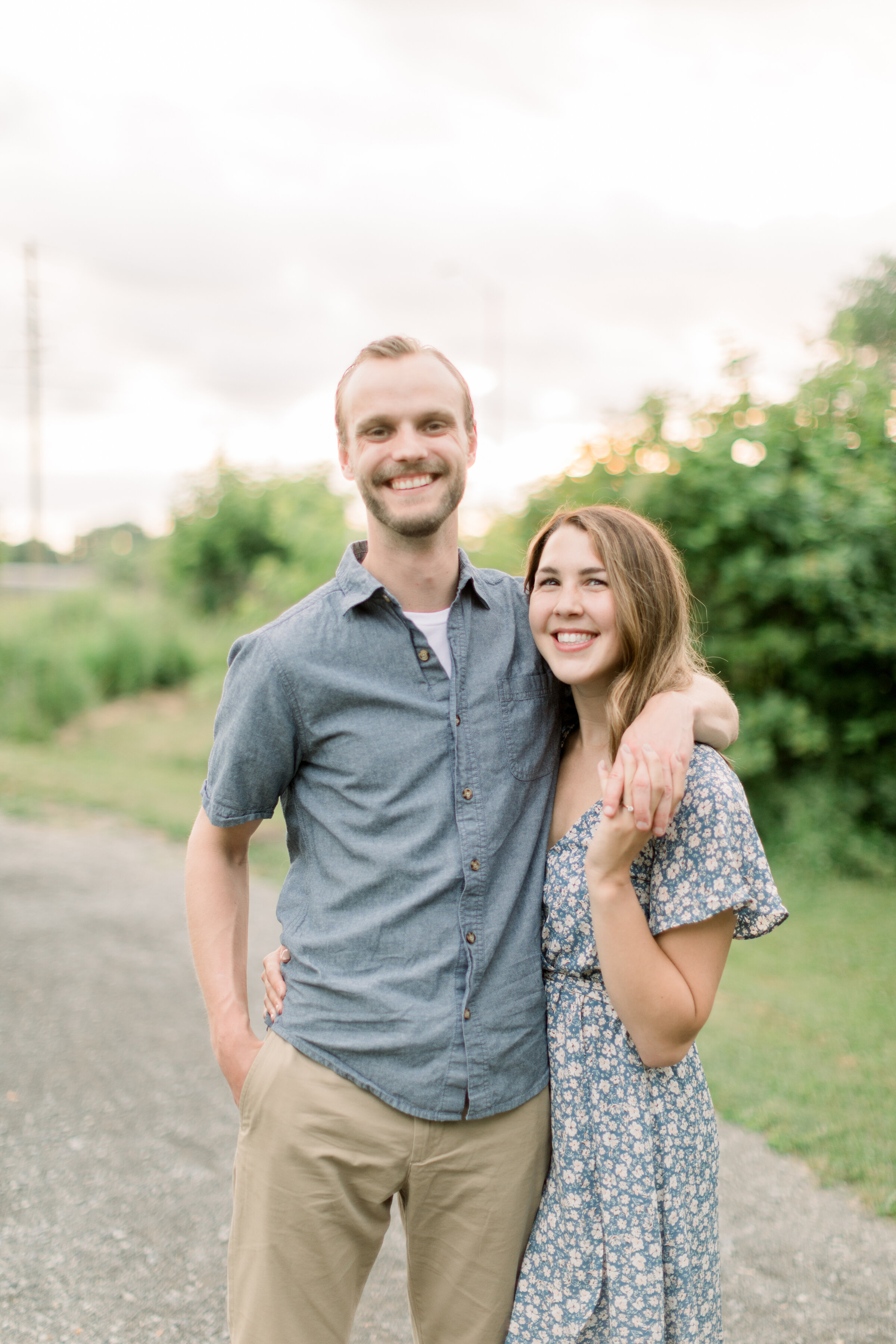  Couple posing for engagements in beautiful outdoor location with blue and white colors for outfit inspo by Chelsea Mason Photography in Ottawa, ON. outfit inspo for engagements summer colors for photoshoot couple outfits for pictures poses for engag