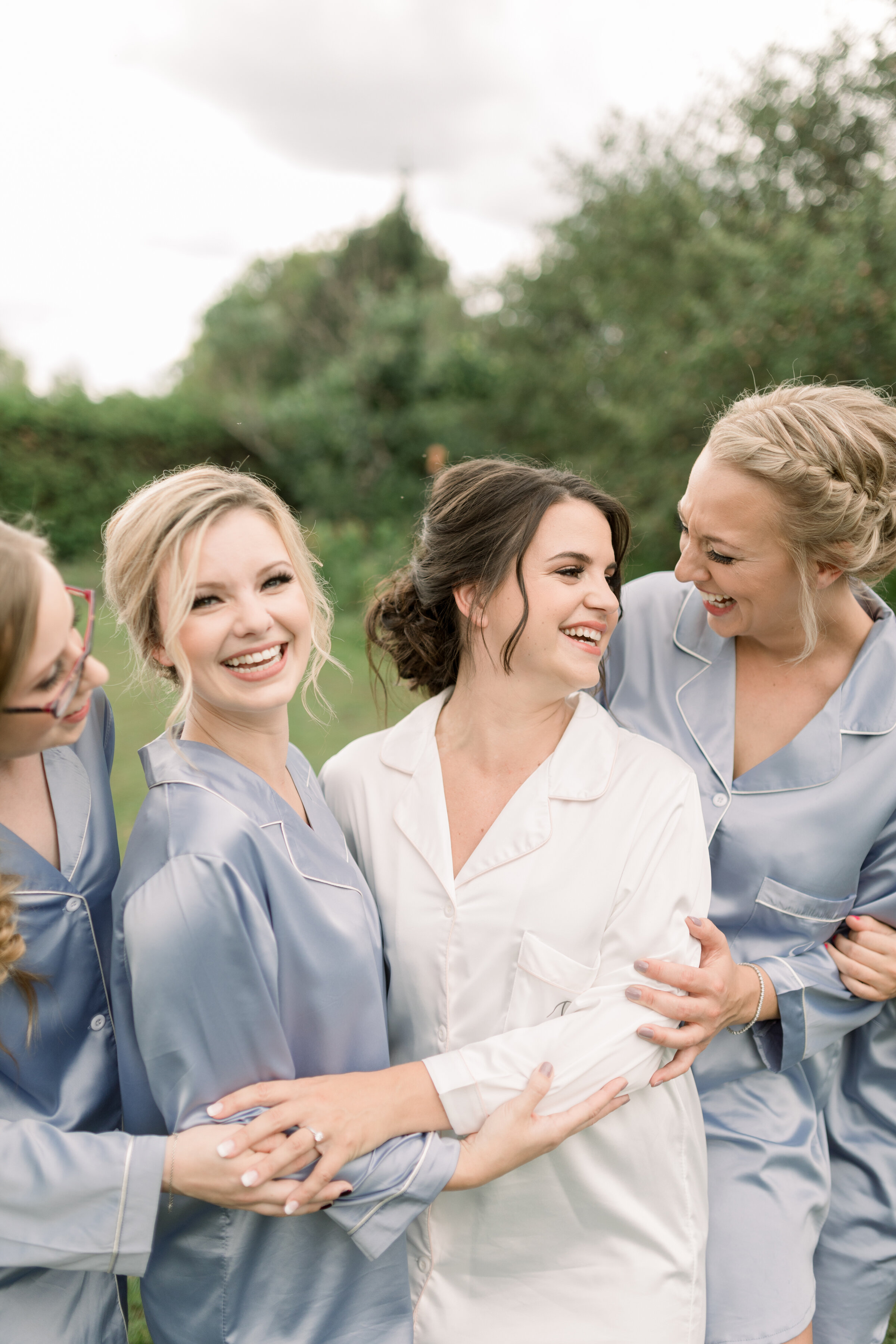  Beautiful pose of bride with bridal party wearing pajamas before they get ready for the ceremony at The Herb Garden by Chelsea Mason Photography. outdoor weddings best wedding photographer in ottawa bridal party ideas how to dress your bridal party 