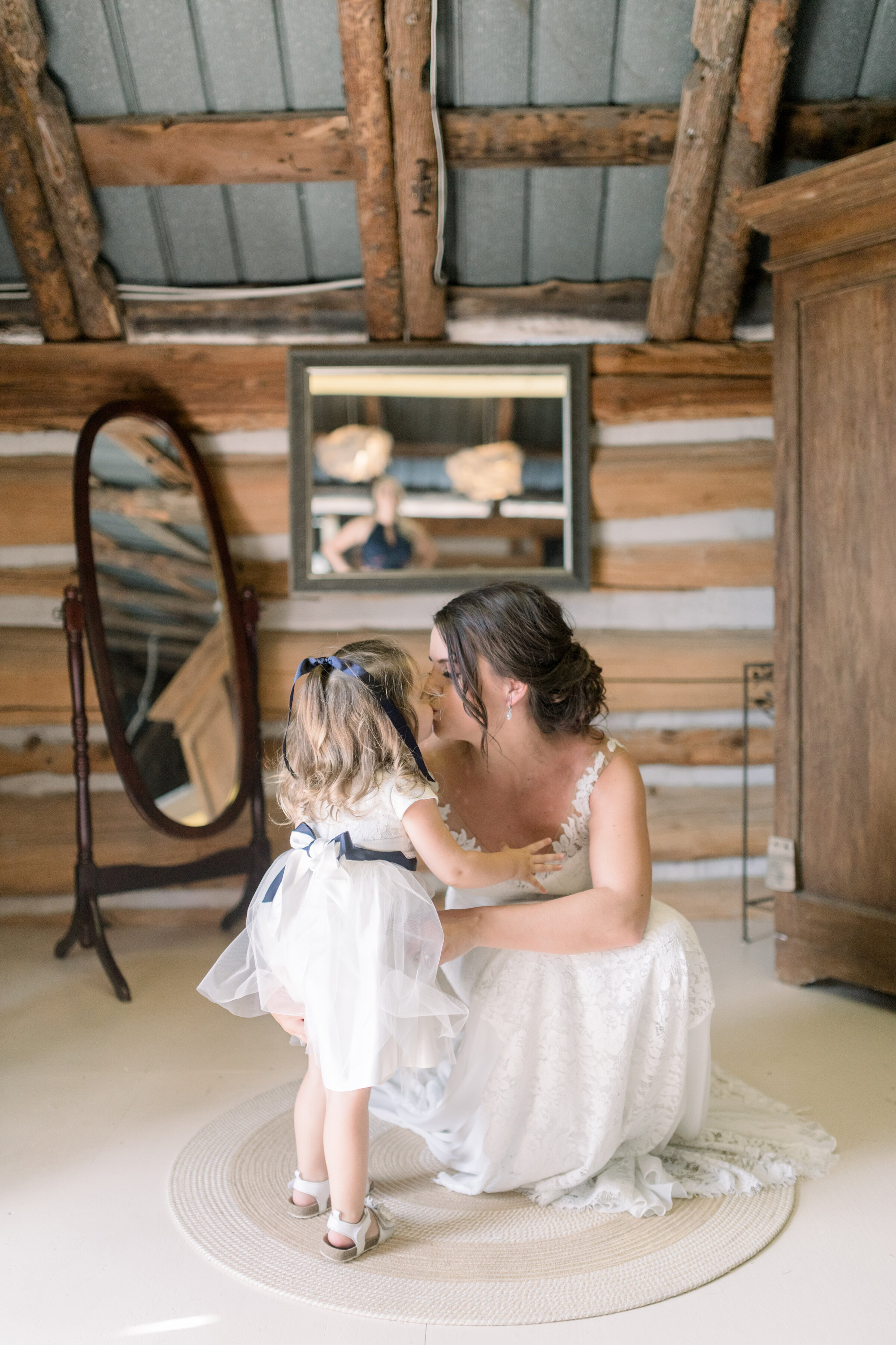  Adorable moment where bride is kissing daughter on wedding day in Ottawa, ON by Chelsea Mason Photography. kids in wedding party how to include your kids in the wedding outfit ideas for kids in wedding mom and daughter on wedding day best wedding ph