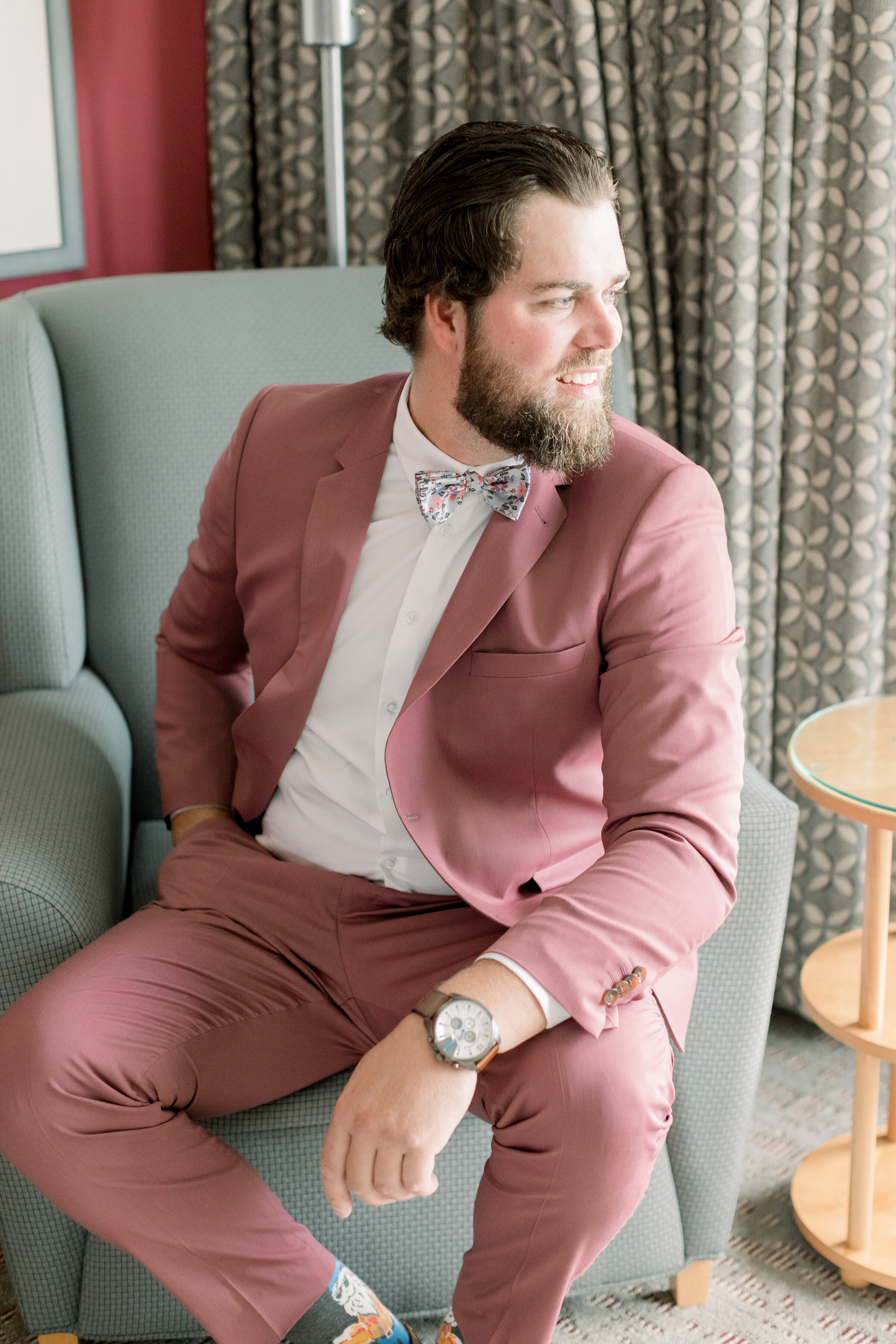  Handsome groom wearing blush pink suit with floral bowtie for outfit inspo by Chelsea Mason Photography in Ottawa, ON. groom outfit inspo unique suits for groom pink for grooms suit blush wedding colors red suit for groom outfit inspo for groom on w