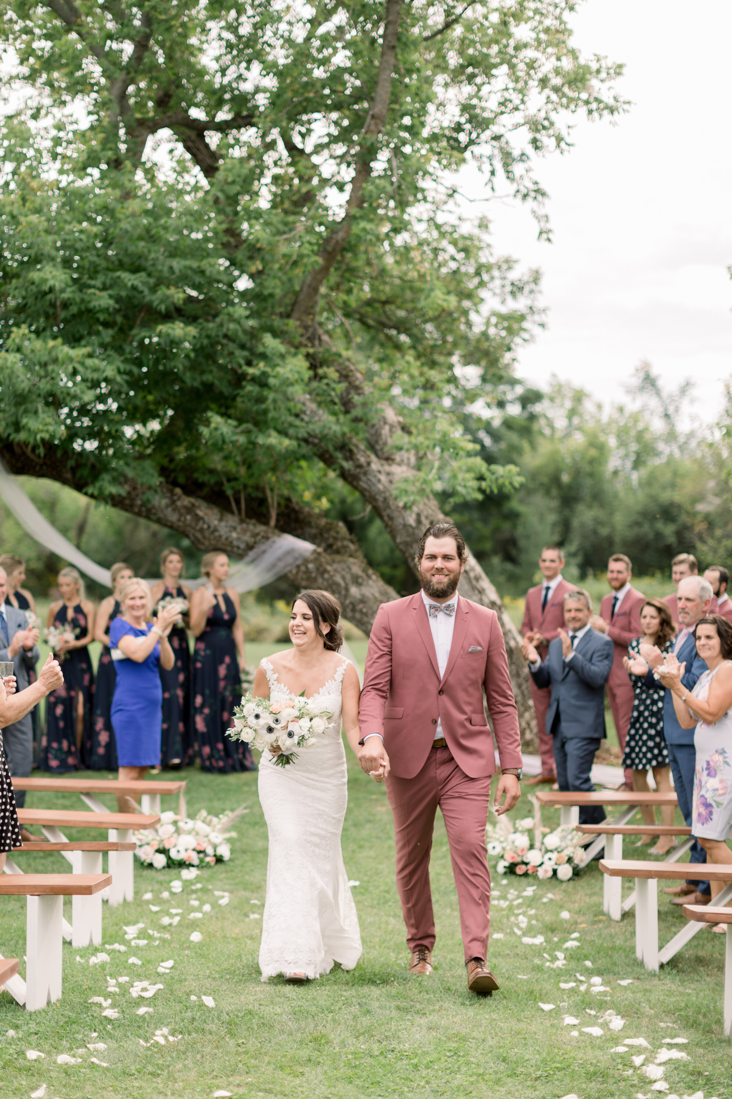  Beautiful couple walking down aisle during their outdoor wedding wearing blue and blush as their wedding colors by Chelsea Mason Photography. outdoor wedding locations making aisles for your wedding how to design your aisle for wedding blush and blu