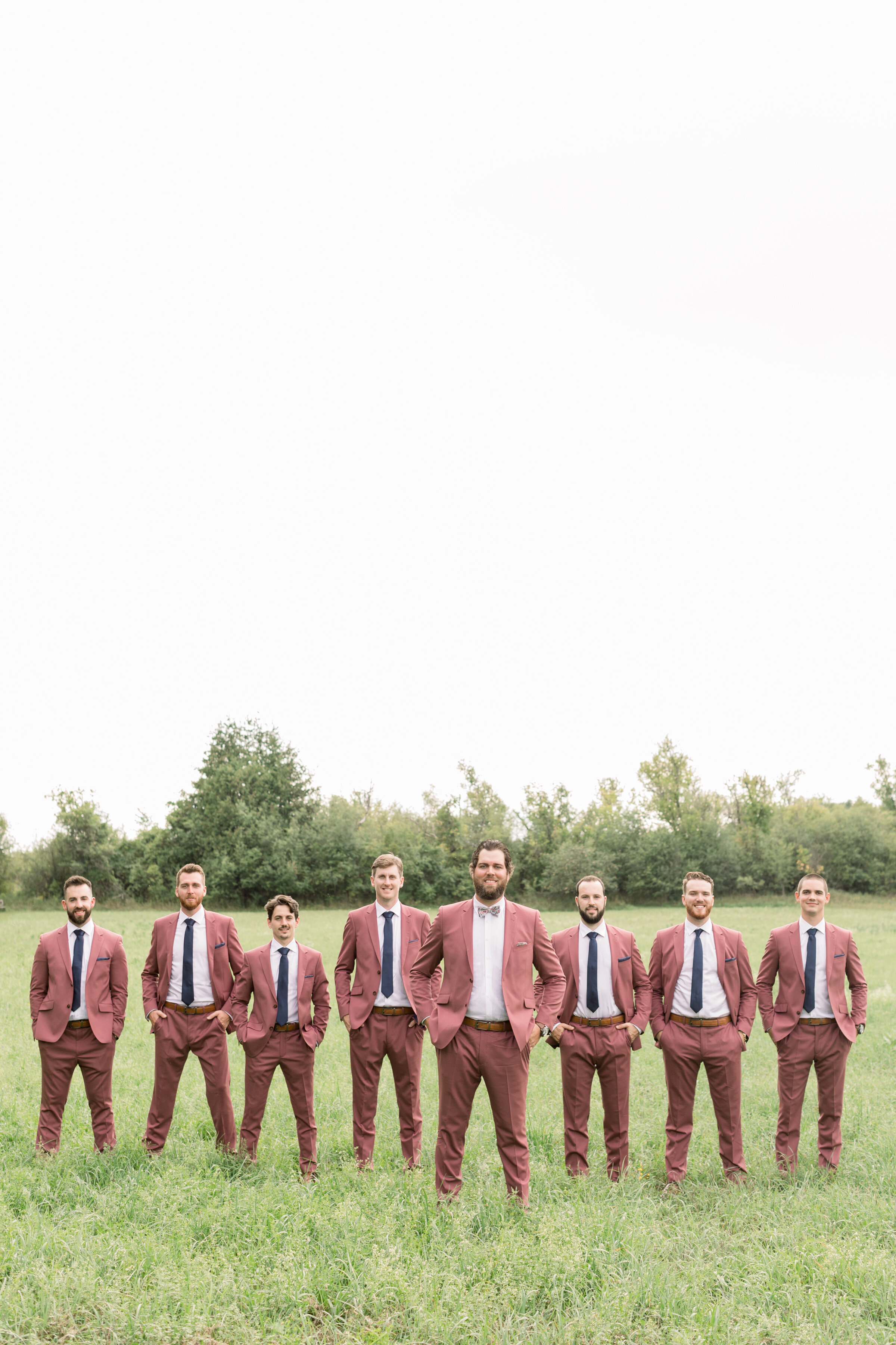  Groom and his groomsmen wearing light red blush suits with navy ties by Chelsea Mason Photography. how to dress your groomsmen matching groom and groomsmen cool wedding colors unique suits for groom how to dress your groom outfit inpso for groom bes