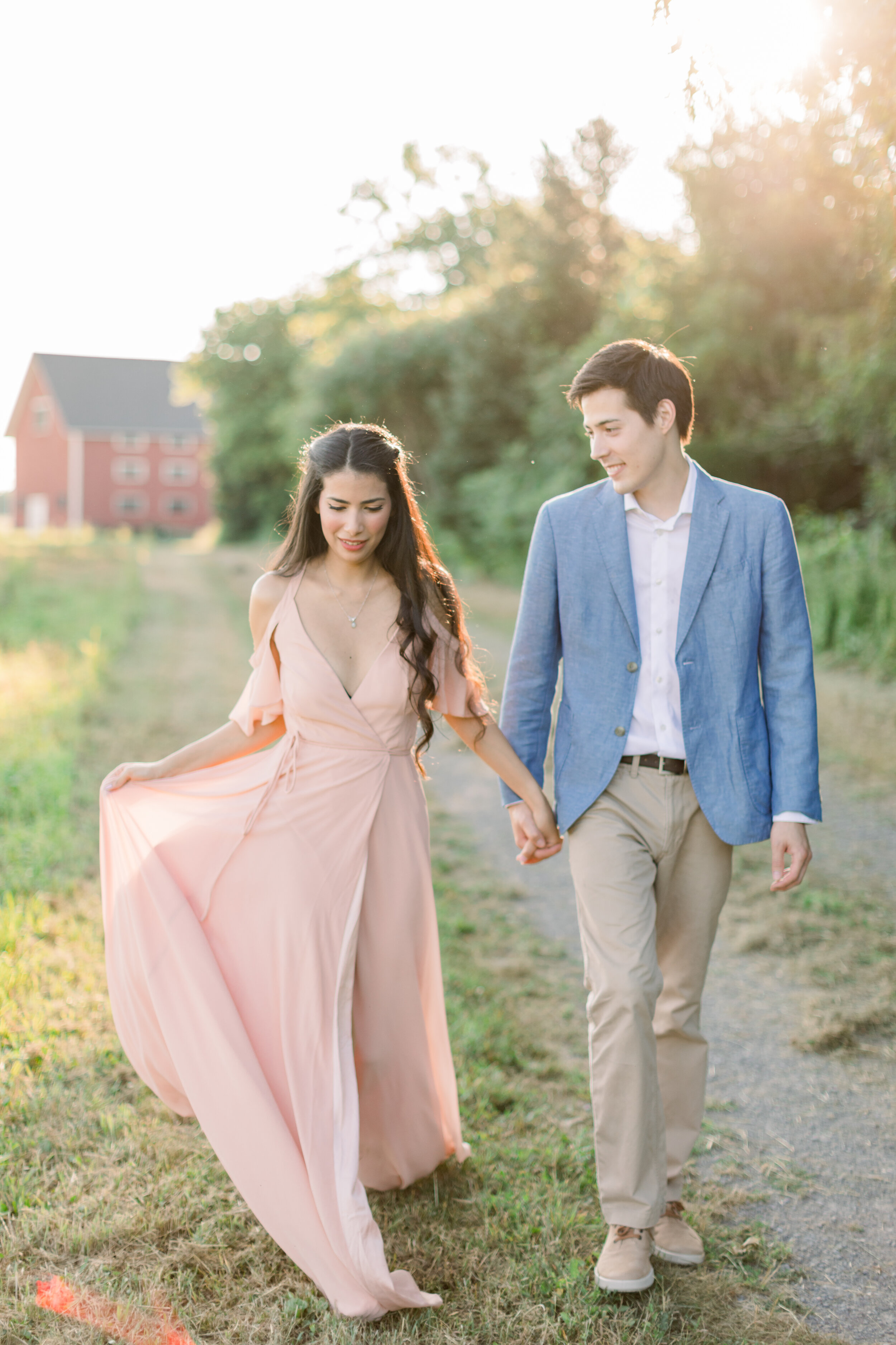  Beautiful couple wearing a pink flowing dress and a blue button up shirt for engagement photo session in Ottawa, ON by Chelsea Mason Photography. outfit inspo for engagements what colors to wear for summer photoshoot best couple colors for engagemen