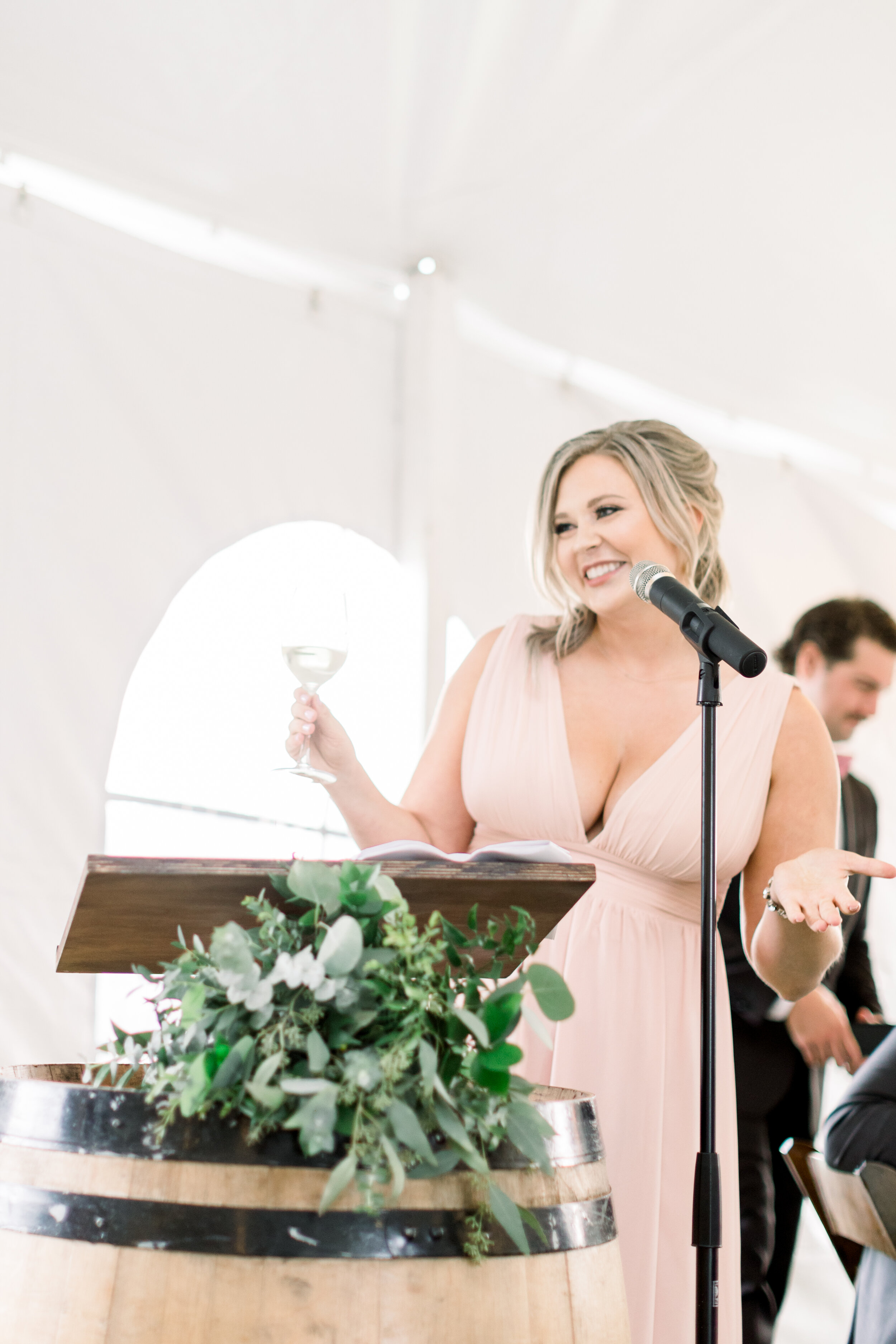  A bridesmaid gives her toast during a beautiful backyard wedding reception in Ottawa, Ontario with Chelsea Mason Photography. Bridesmaid toast wedding reception details light pink bridesmaid dress inspo bride and groom candid moments elegant wedding