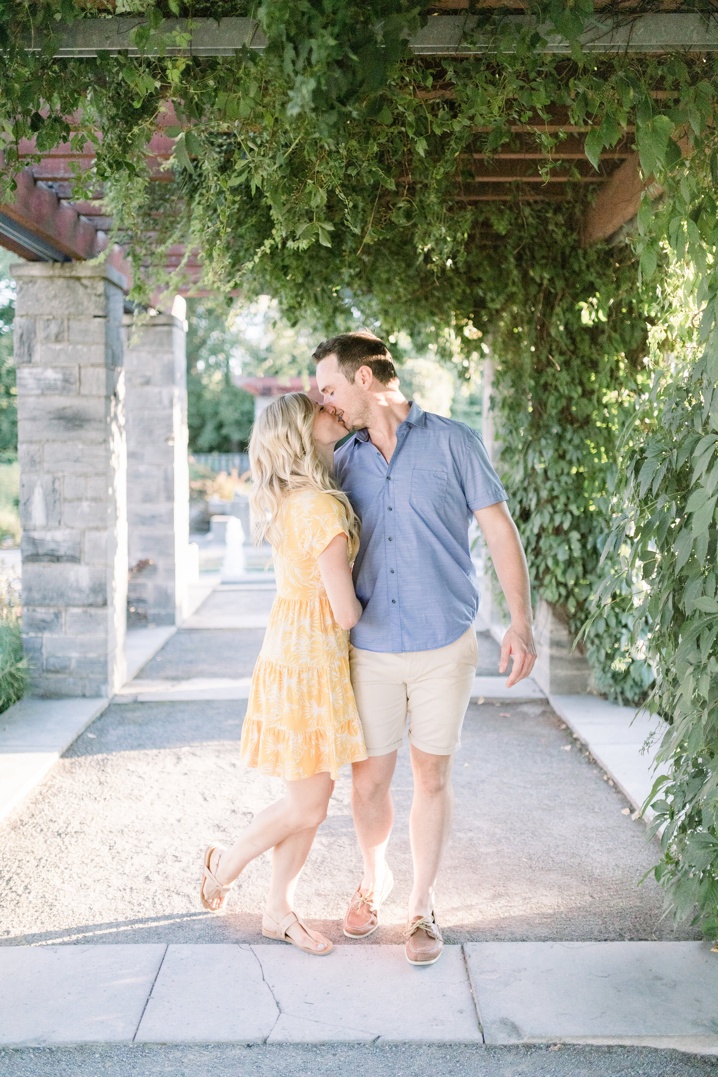  A couple share a kiss in the Botanical Gardens of Montreal Canada. Engagement session location inspiration professional engagement photographer outdoor photo shoot inspiration ideas and goals couple goals couple pose inspiration ideas and goals spri