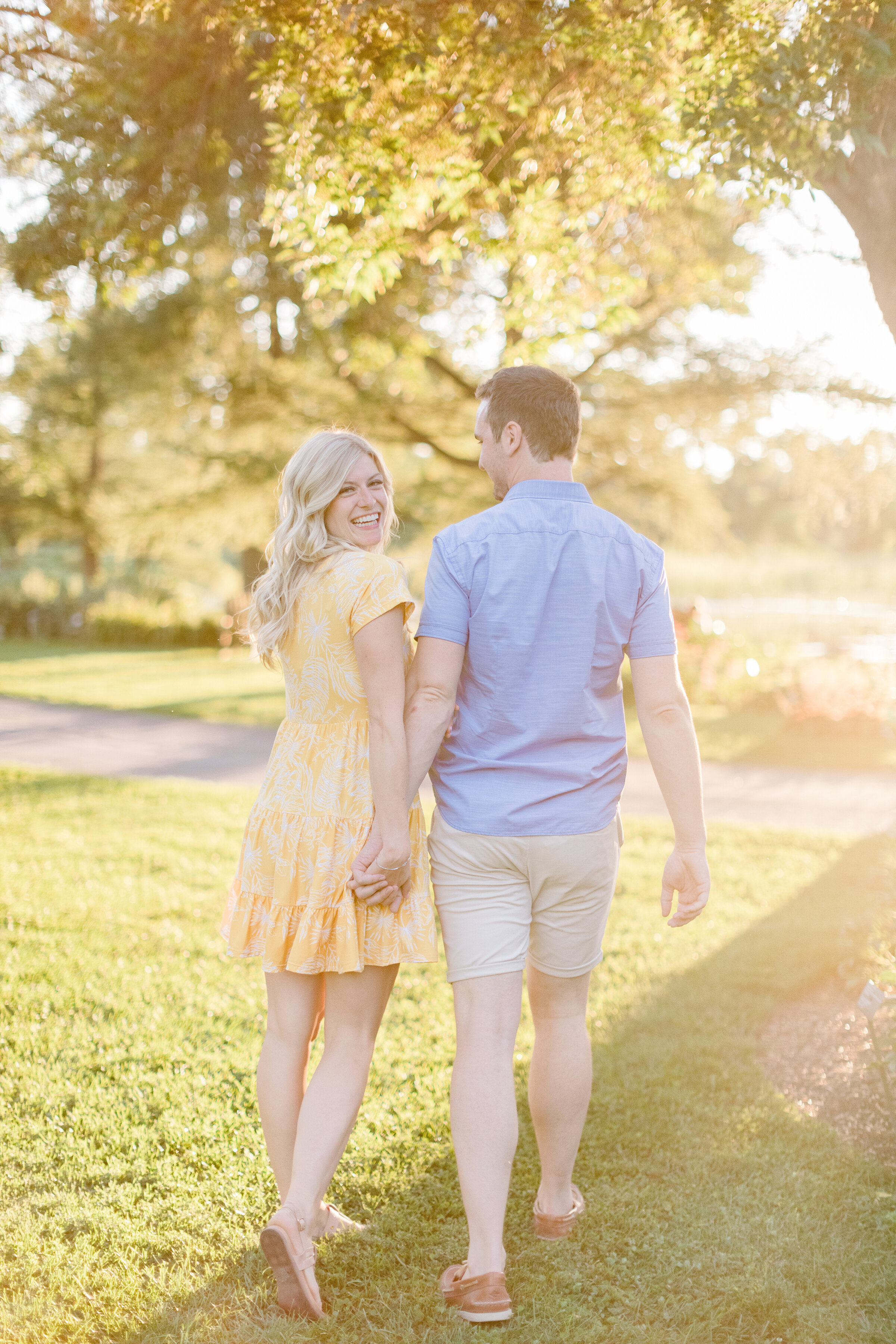  A beautiful couple walk into the sun in a bright and airy engagement session in Montreal Canada. Botanical Garden professional engagement photographer Chelsea Mason Photography outdoor engagement session walking couple pose inspiration looking back 