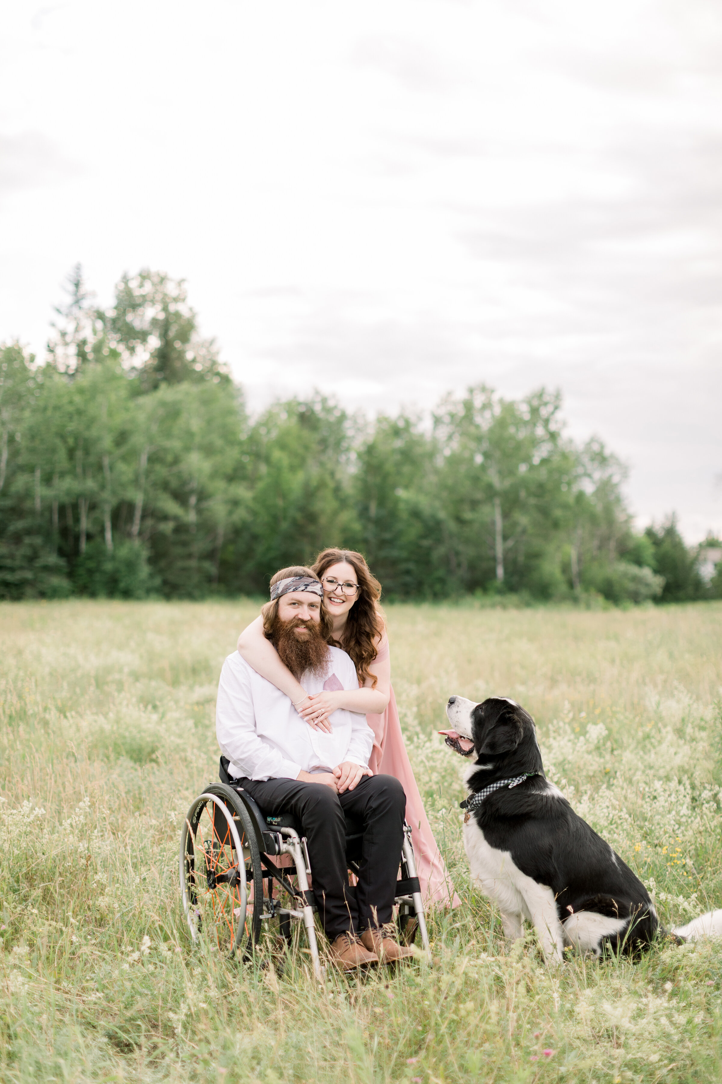  A beautiful couple pose together with their dog in a rustic outdoor engagement session in Ontario, Canada by Chelsea Mason Photography. Client pose inspiration pose with dog inspiration ideas and goals engagement session inspiration outdoor session 