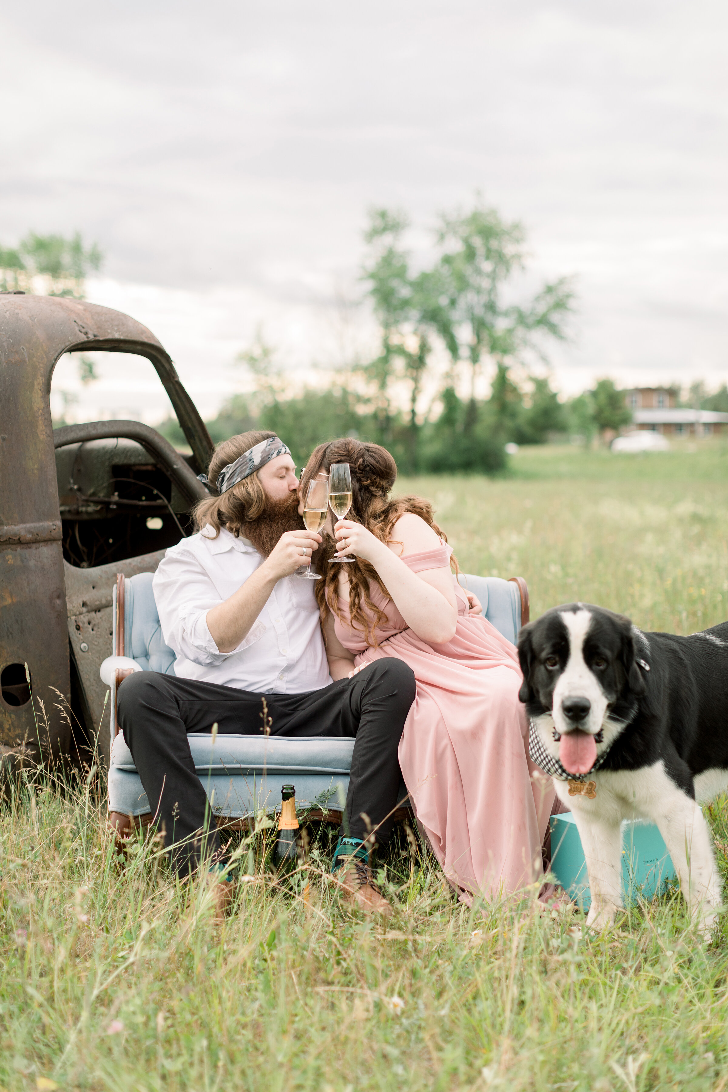  A couple share a kiss and they cheers to a new life together in a beautiful rustic outdoor engagement session by Chelsea Mason Photography. Couple pose with dog inspiration ideas and goals engagement session inspiration ideas and goals location insp