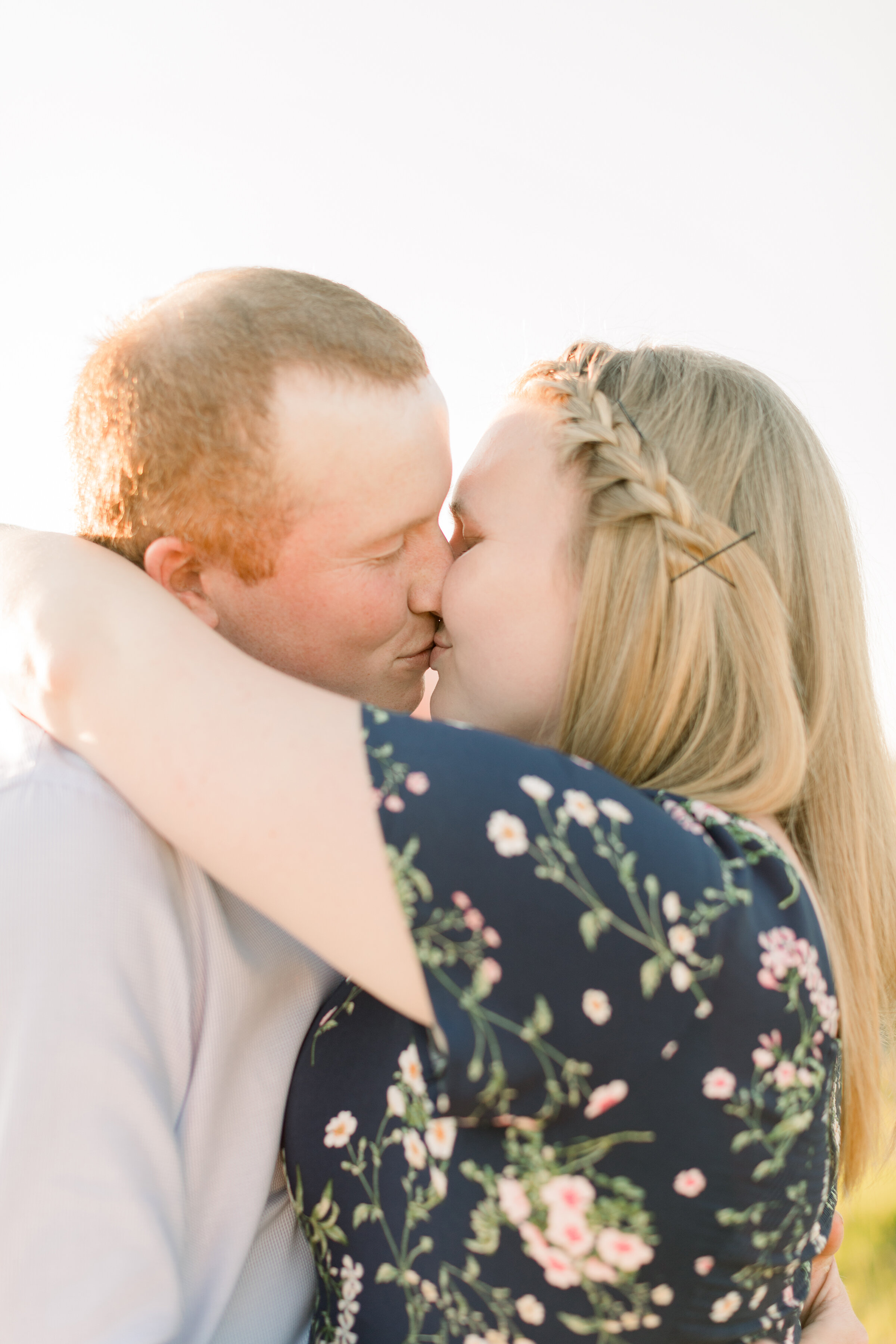  A glowing couple kiss each other in a warm and bright engagement session by Chelsea Mason Photography. Engagement session pose inspiration ideas and goals couple goals engagement session goals professional photographer client attire inspiration semi