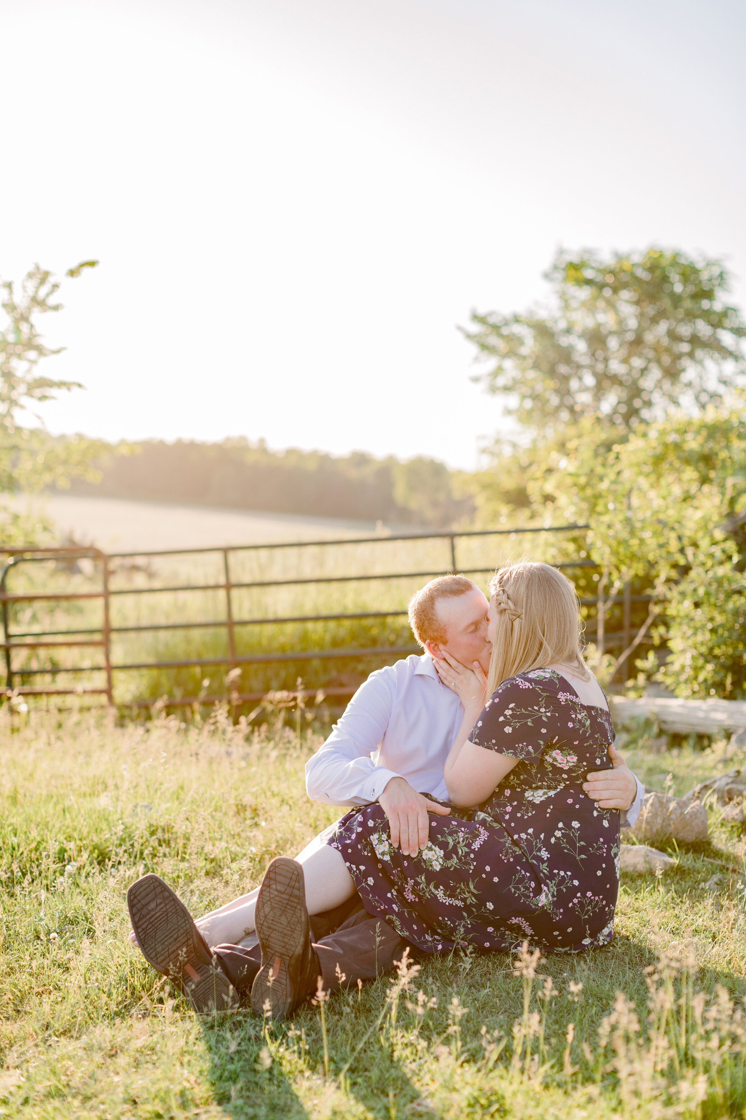  A newly engaged couple kiss on the grassy hill as the sun sets in a beautiful engagement session on the farm. Professional photographer Chelsea Mason Photography country styled engagement session country client attire for engagement sessions client 