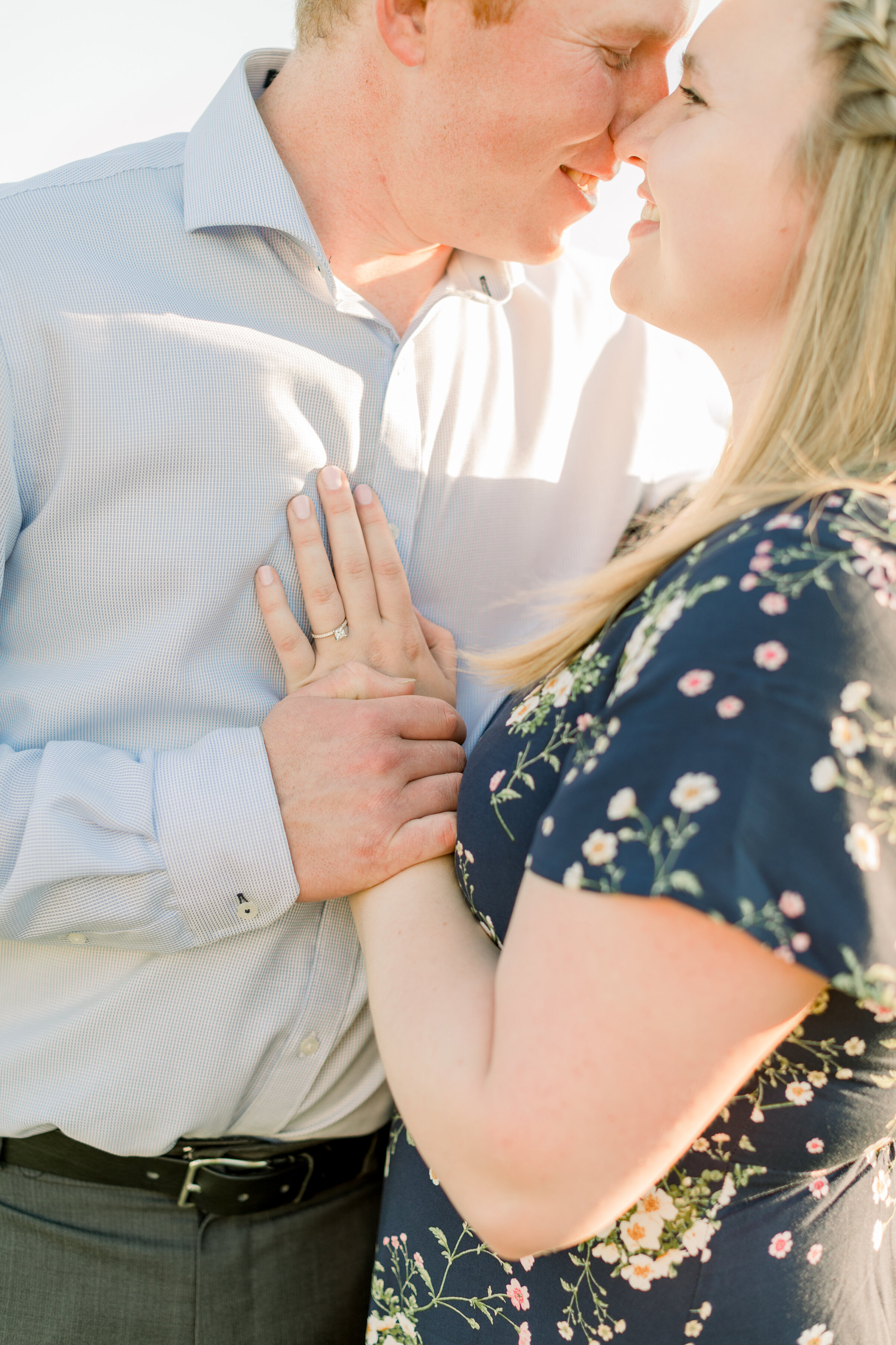  A groom holds his fiancé close in a beautiful romantic engagement session by Chelsea Mason Photography. Close up couple pose inspiration ideas and goals couple goals romantic couple pose inspiration bright and airy professional engagement photograph