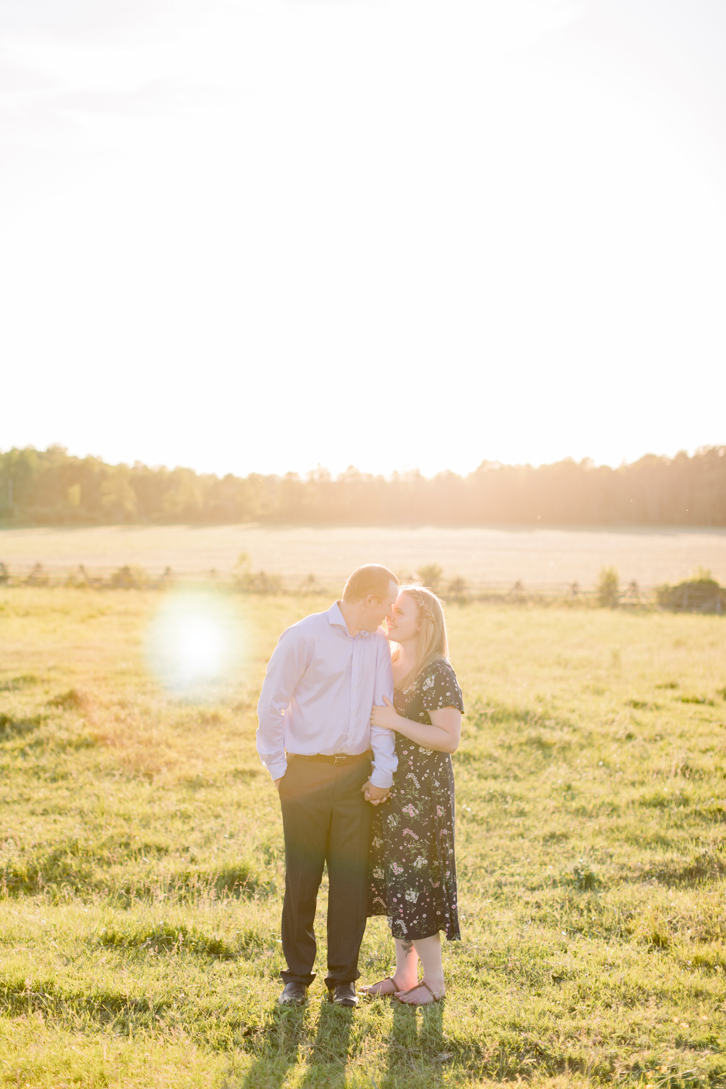  A couple kiss and the sun sets on the grassy field in a stunning country styled engagement session on the farm. Chelsea Mason Photography engagement session goals ideas and inspiration client attire farm aesthetic outdoor photo shoot session couple 