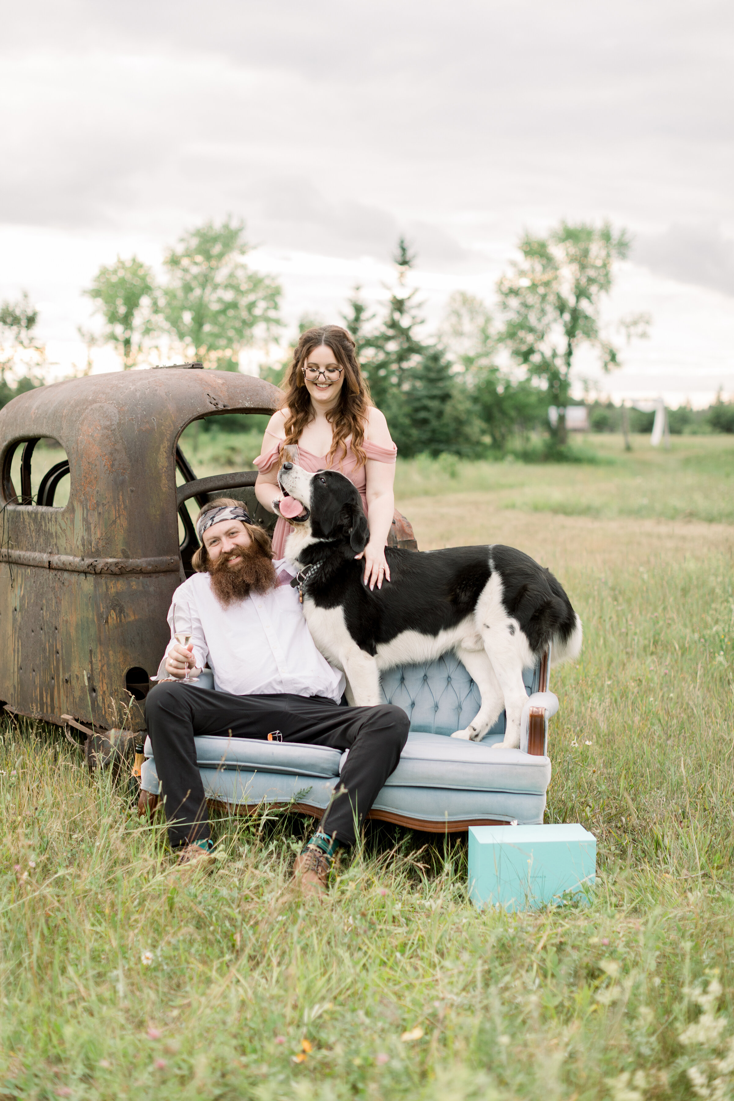  A couple celebrate the engagement with Champaign as their dog joins the fun in a unique outdoor engagement photo shoot by Chelsea Mason Photography. Outdoor engagement session inspiration ideas and goals for Smith Falls Ontario Canada engagement loc