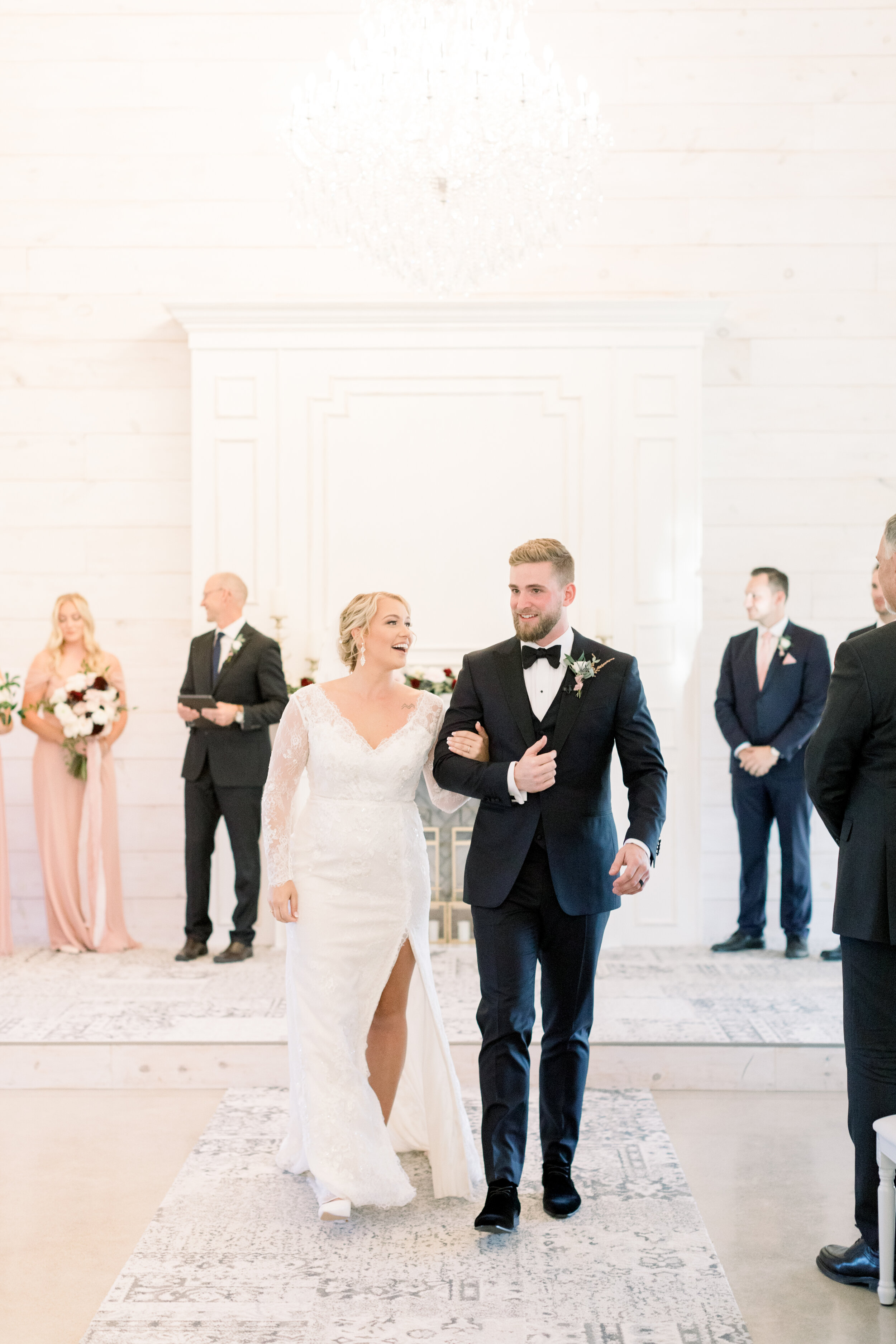  Handsome groom escourting his newly wed wife in a lace wedding dress with a high slit down the aisle after saying I do at stonefield wedding venue in Ottowa. Wedding dress with slits lace wedding dress inspo bridal shoes wedding ceremony grand exit 