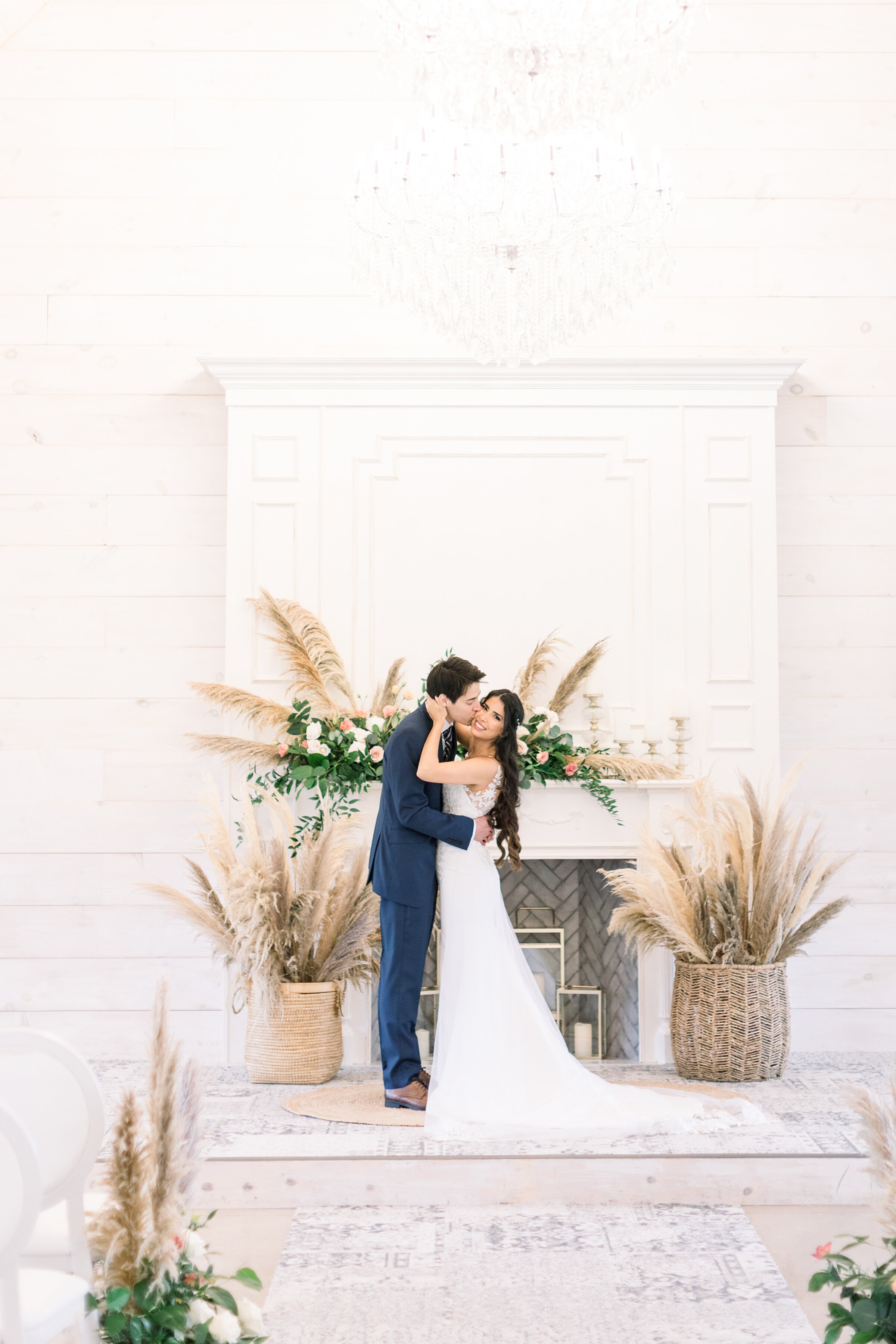  A handsome groom kisses his stunning bride on the cheek under a crystal chandelier  at the wedding alter at Stonefields Estates, Ottawa by Chelsea Mason Photography. Professional Ottawa wedding photographer wedding day pose inspiration ideas and goa