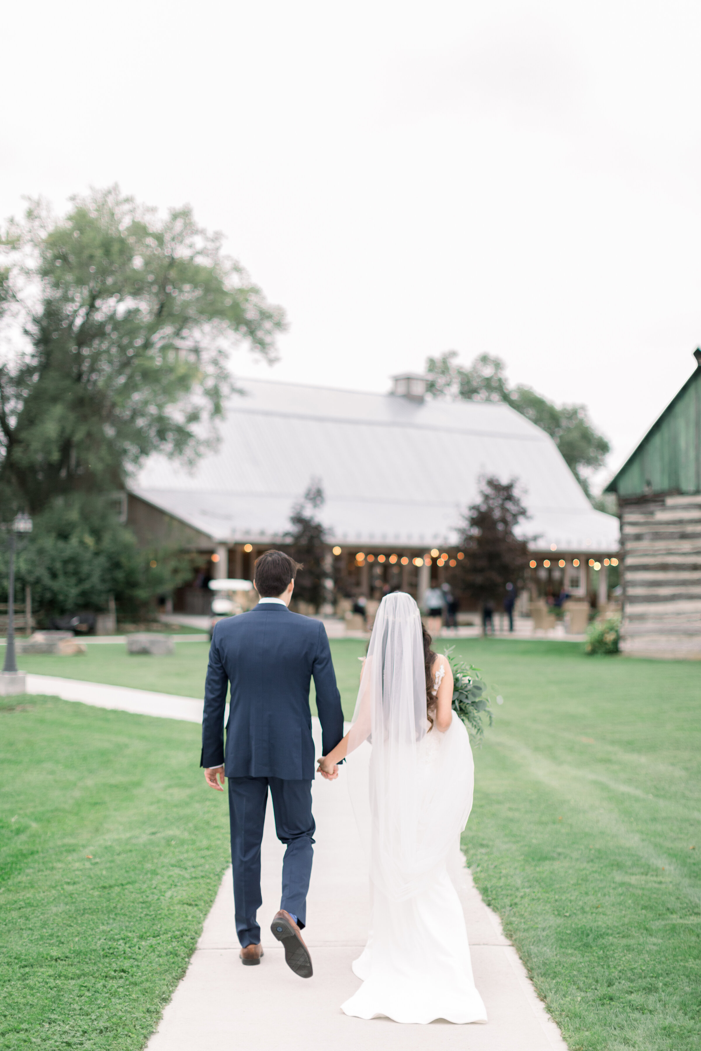  A newly wed couple walk hand in hand to the wedding reception on the stunning Stonefields Estates, Carleton Place Ottawa by Chelsea Mason Photography. Rustic and chic wedding aesthetic wedding day photo shoot inspiration ideas and goals wedding loca