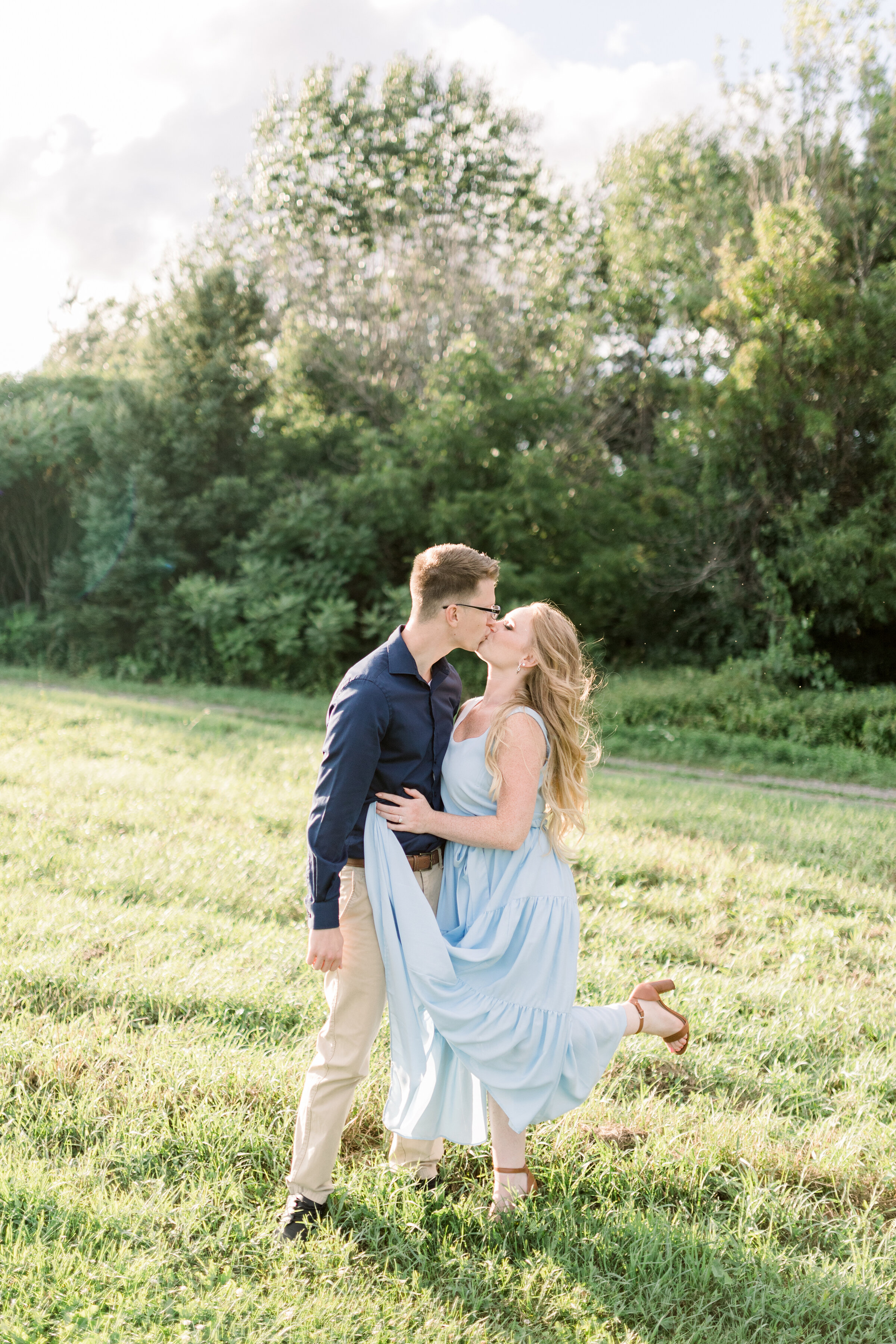  A beautiful couple kiss on a grassy hill in Dominion Arboretum, Ottawa in an engagement styled photo shoot by professional photographer Chelsea Mason Photography. Summer goals engagement location inspiration ideas and goals couple goals Ottawa engag