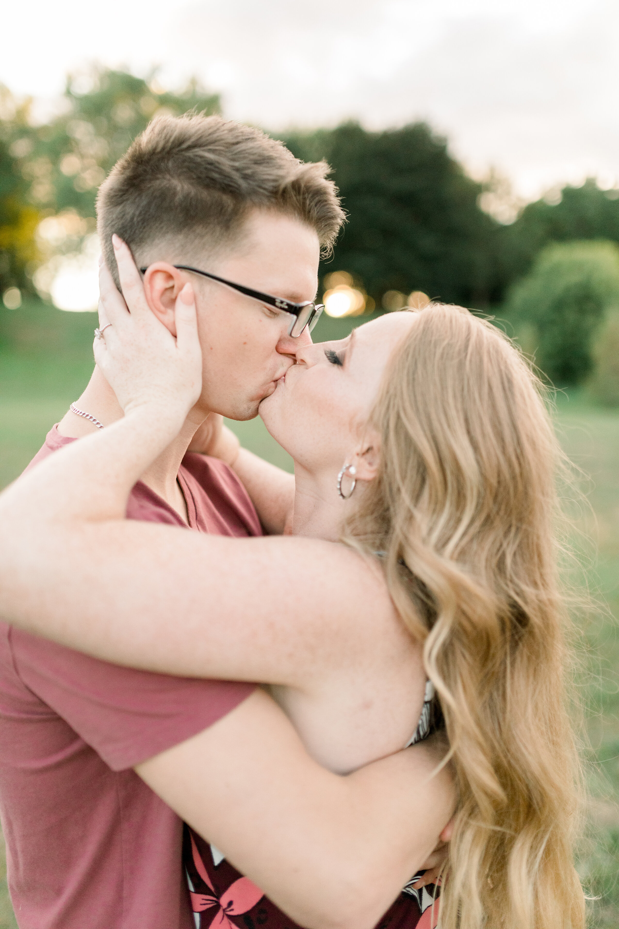  A beautiful women holds her fiancé as they kiss in a beautiful engagement session at Dominion Arboretum in Ottawa by Chelsea Mason Photography. Professional engagement photographer couple goals couple kissing inspiration ideas and goals couple pose 