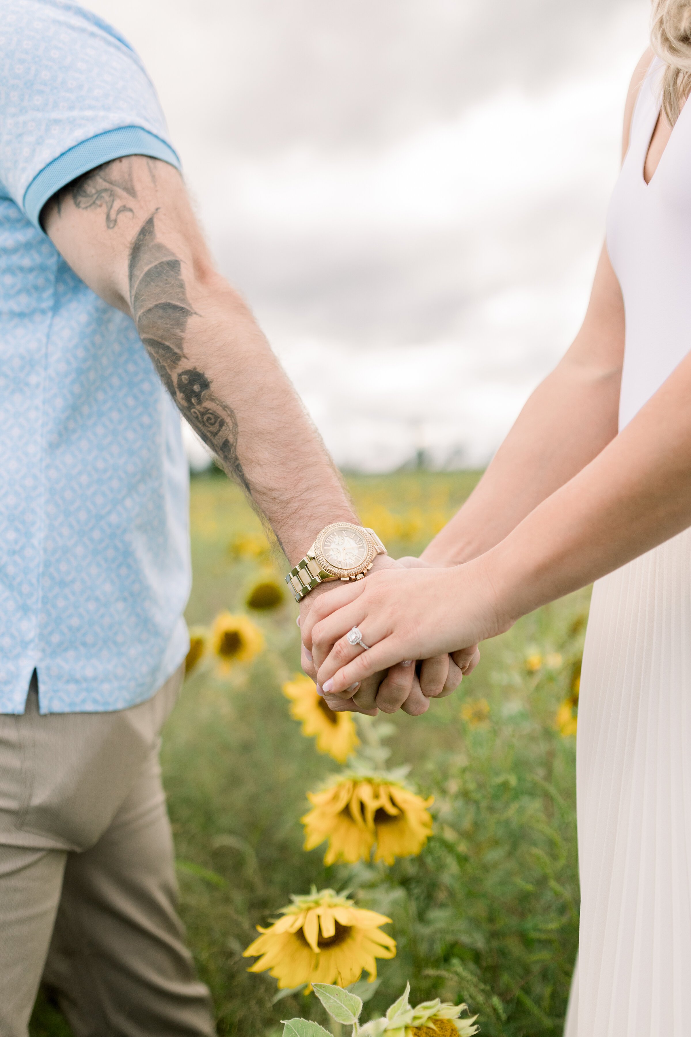  A soon to be bride holds her fiancés hand as she shows off her stunning wedding ring in Ottawa, Ontario. Chelsea Mason Photography couple goals couple pose inspiration client attire inspiration ideas and goals for men and women  outdoor goals sunflo