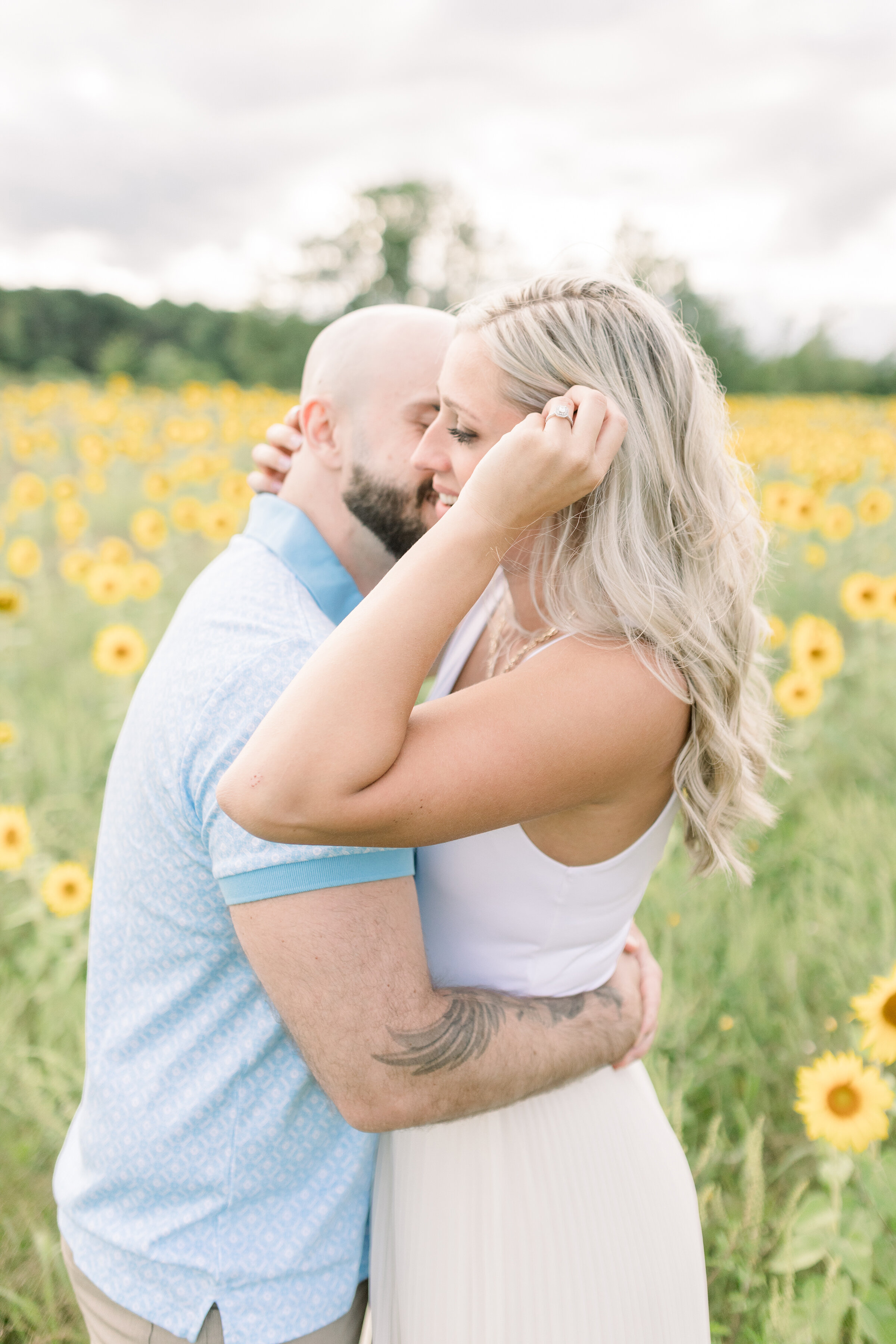  A handsome man kisses his soon to be wife on the cheek as she pushes she hair aside in a beautiful Ottawa, Ontario engagement session by Chelsea Mason Photography. Professional engagement photographer couple goals couple pose inspiration ideas and g