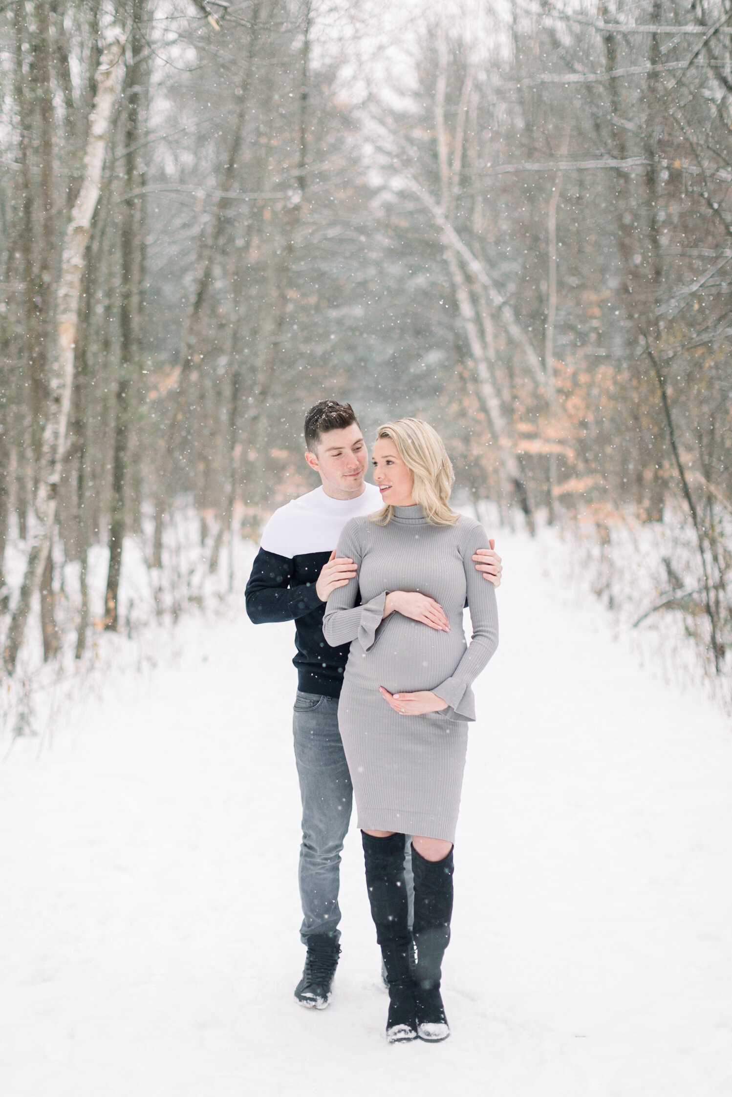  A husband holds his glowing wife as she cradles her pregnant belly  in a beautiful Pinhey’s Trails, Ottawa photo shoot session by Chelsea Mason Photography.   Couple goals maternity session inspiration ideas and goals winter goals outdoor photo shoo