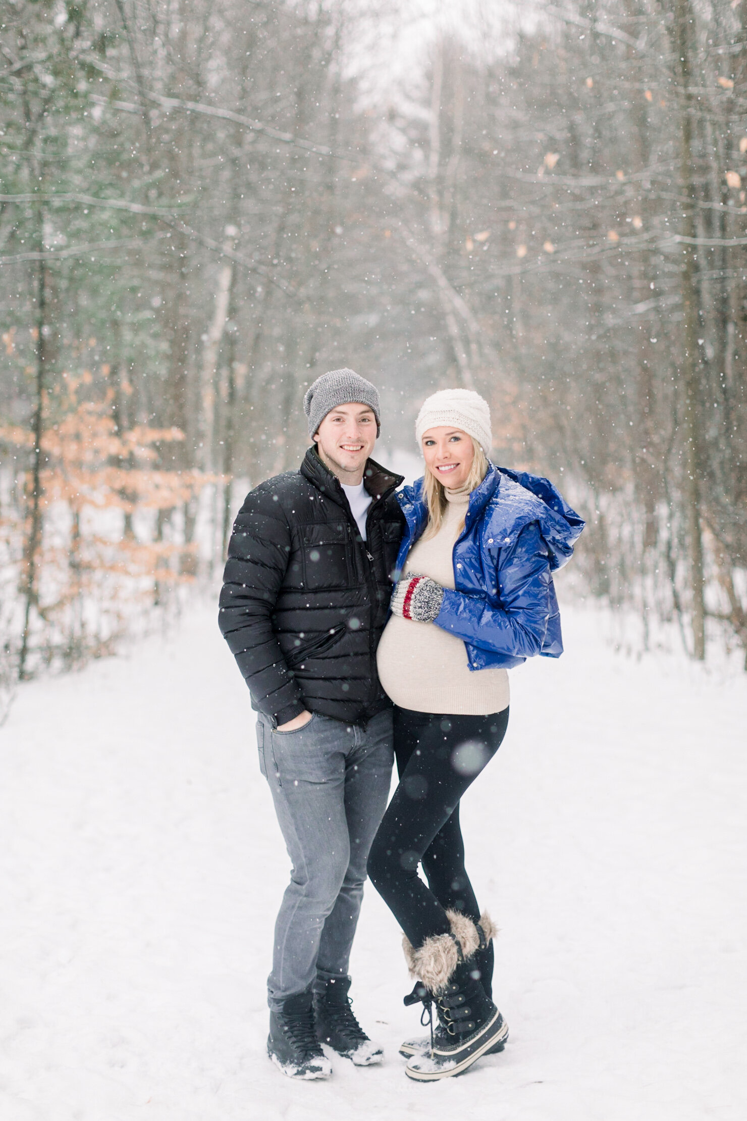  A beautiful couple stand together and she holds her baby bump in a winter wonderland maternity session by professional Ottawa photographer Chelsea Mason Photography. Pinhey’s Trails photo shoot inspiration ideas and goals winter maternity session go